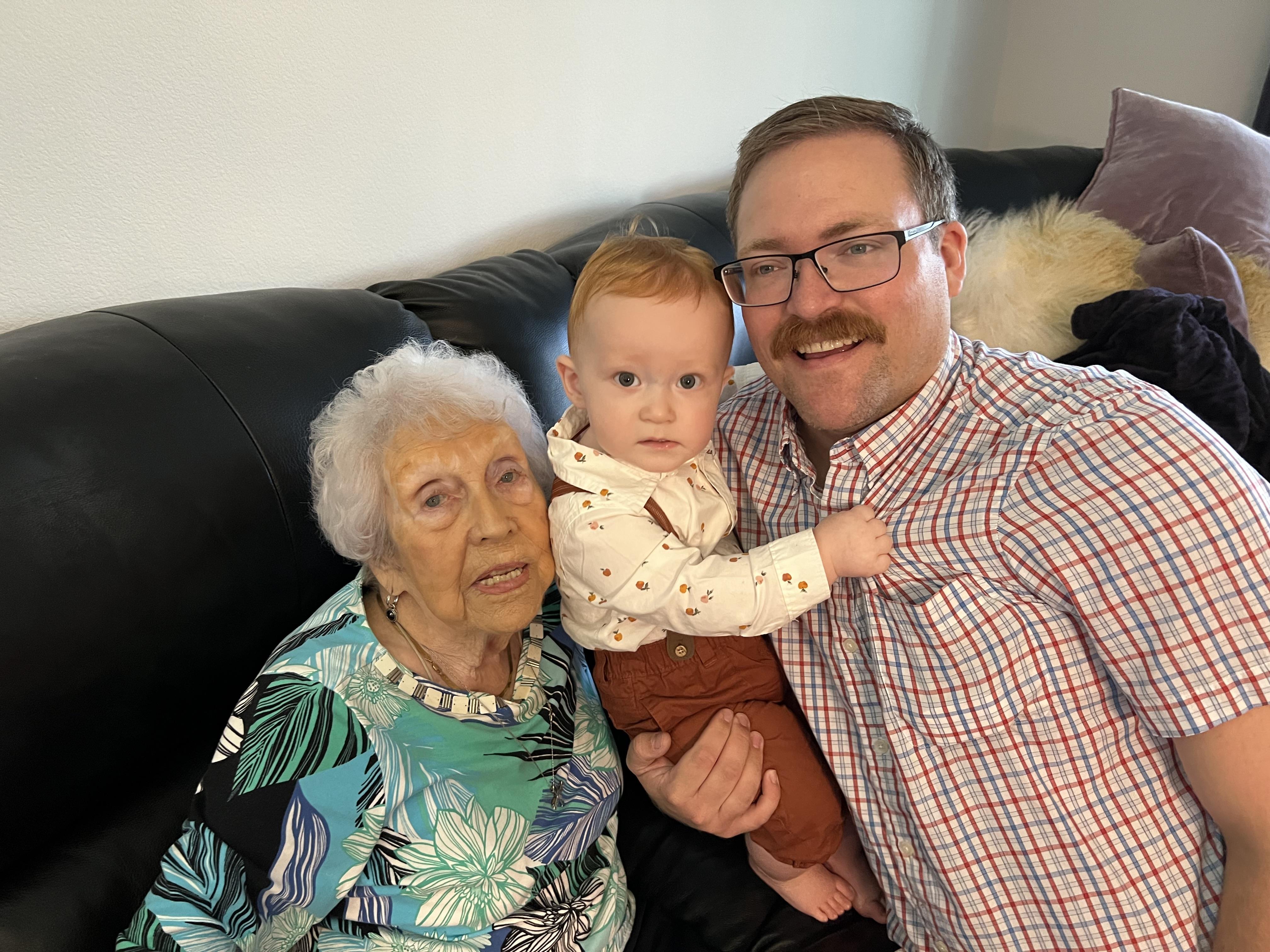 Three generations of family share a warm moment together in a cozy living room.