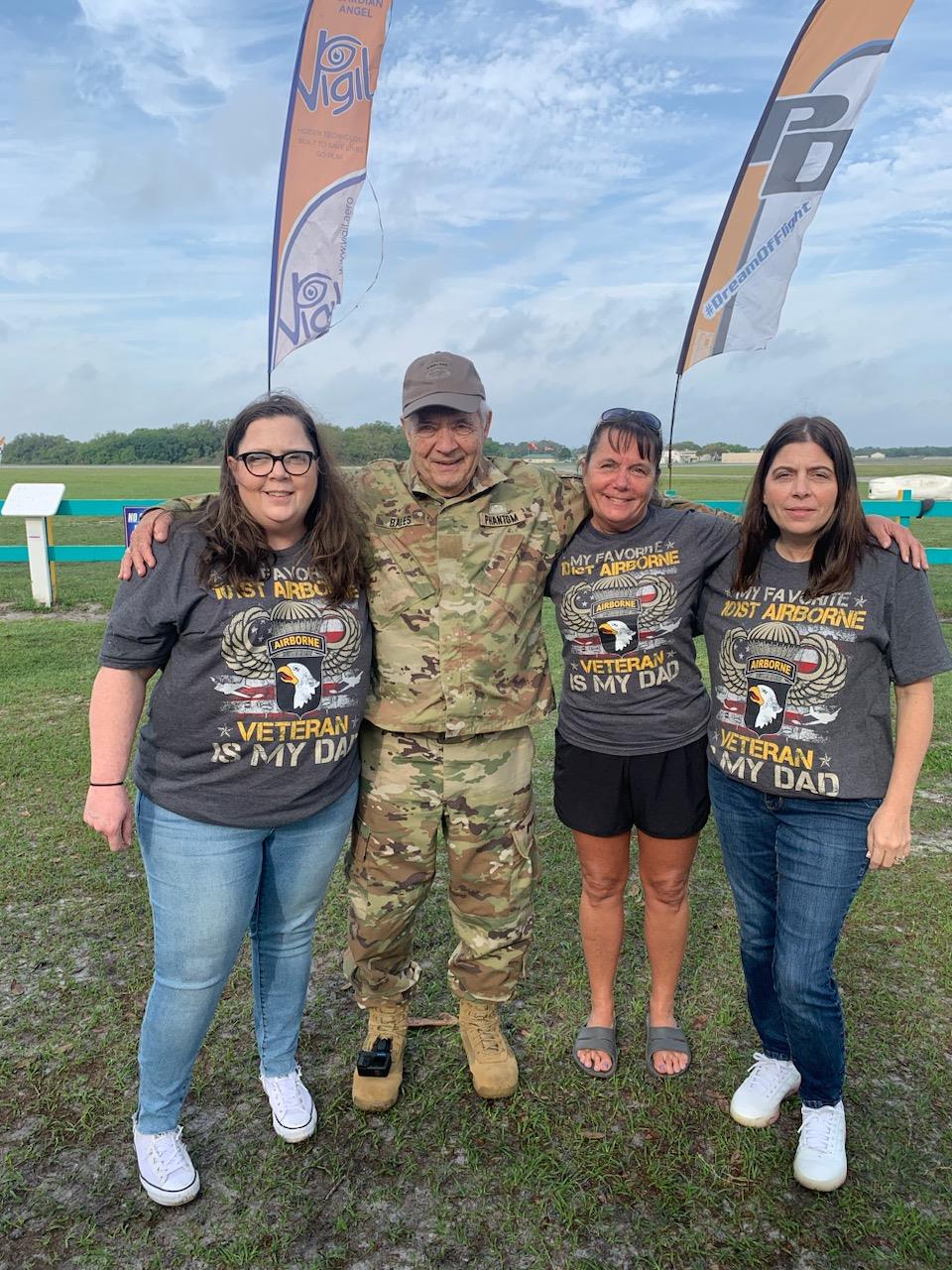 A service member celebrates with family at an outdoor veterans appreciation event.