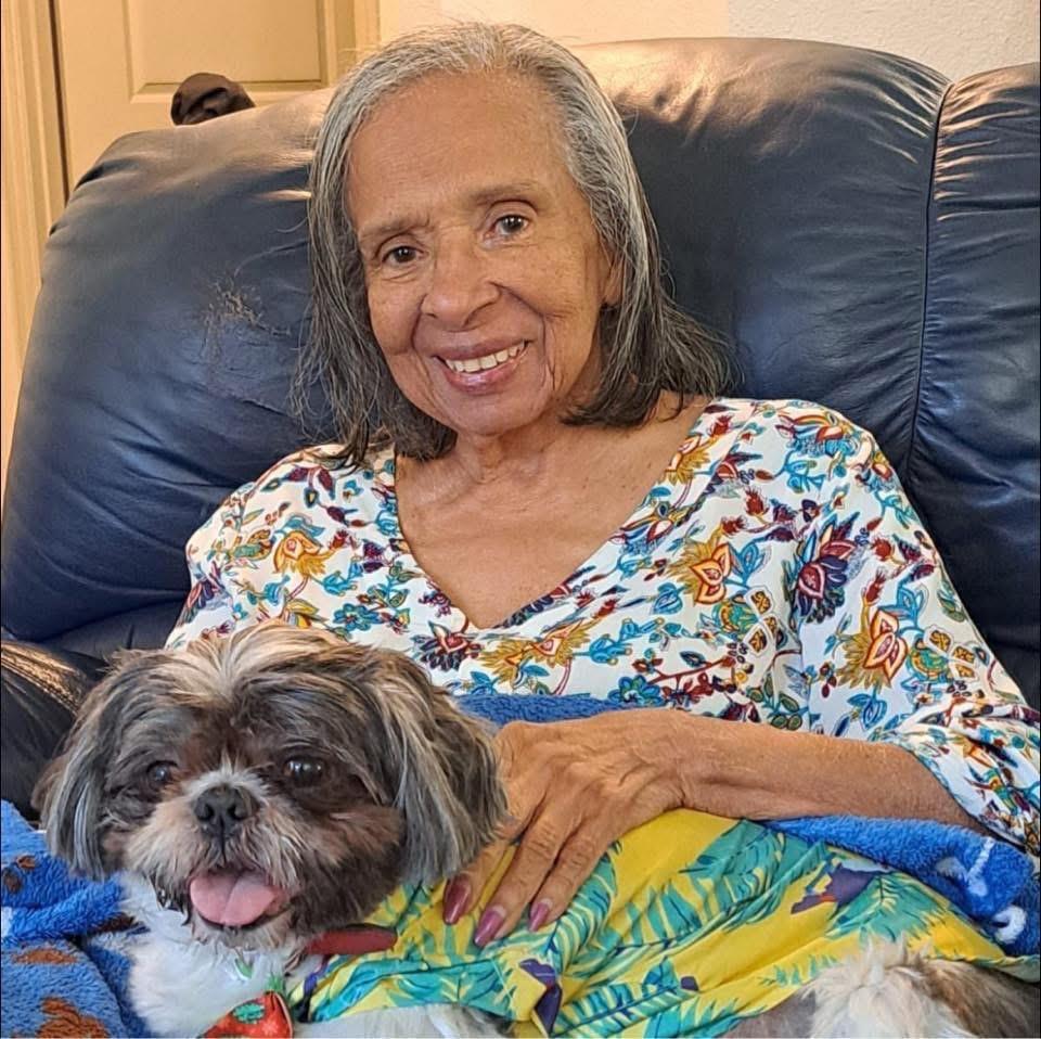 A woman enjoys a peaceful moment with her small dog, both looking content and relaxed together.