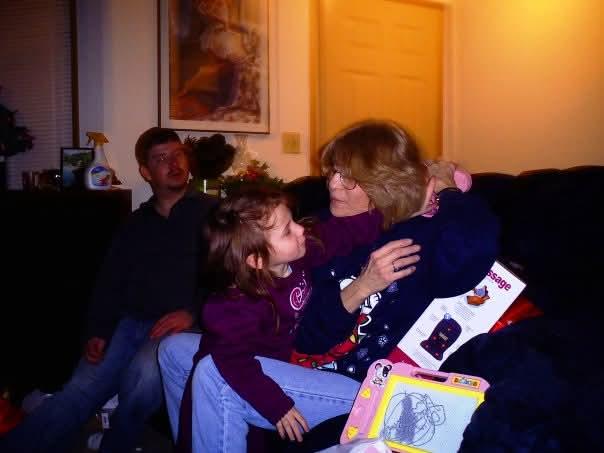 Children interact playfully with adults in a warm, inviting living room during a family gathering.