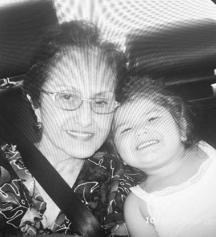 Grandmother and granddaughter share a joyful moment during a car ride, smiling happily.