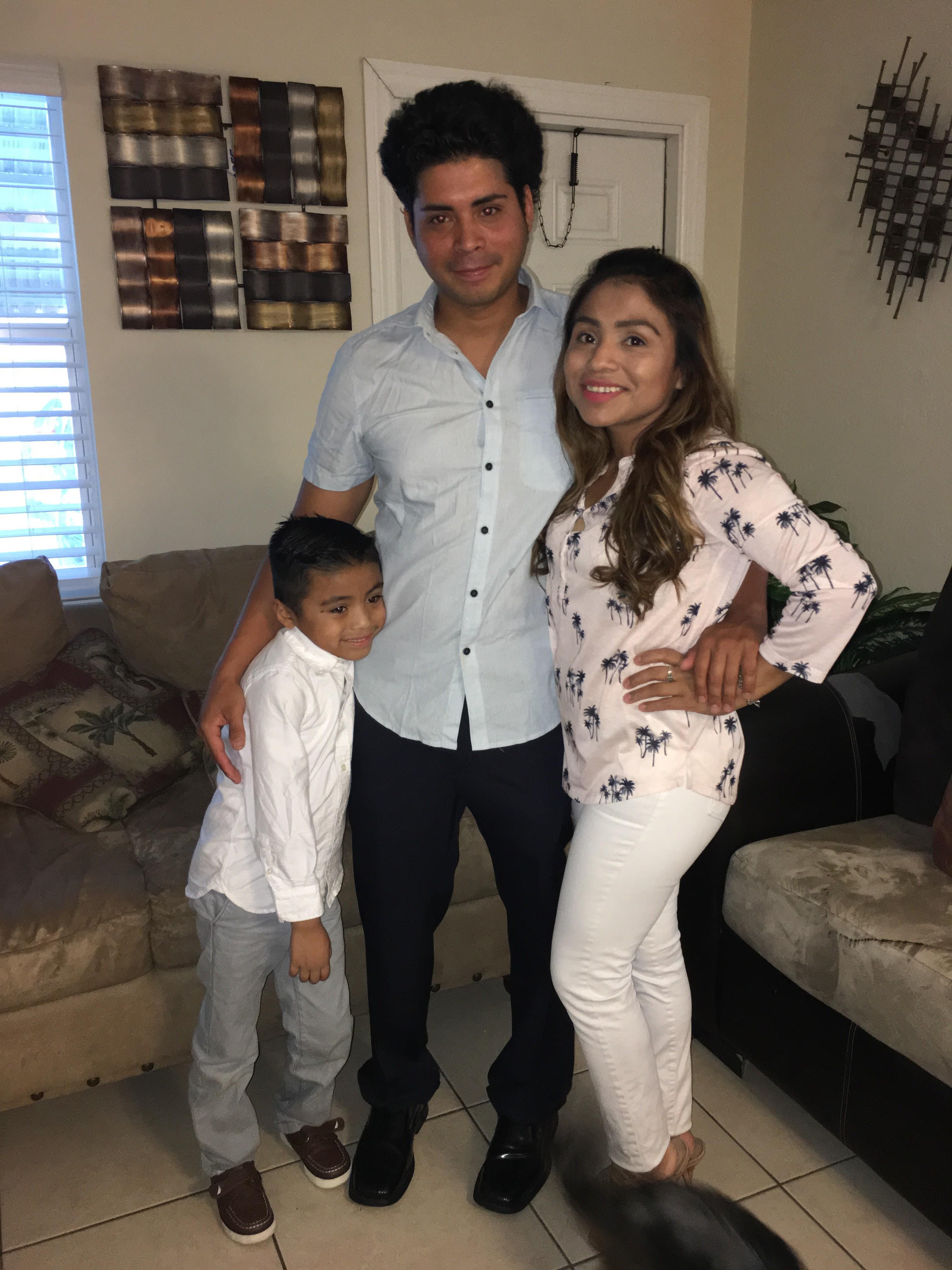 A family stands together in a living room, celebrating a special occasion with smiles and warmth.