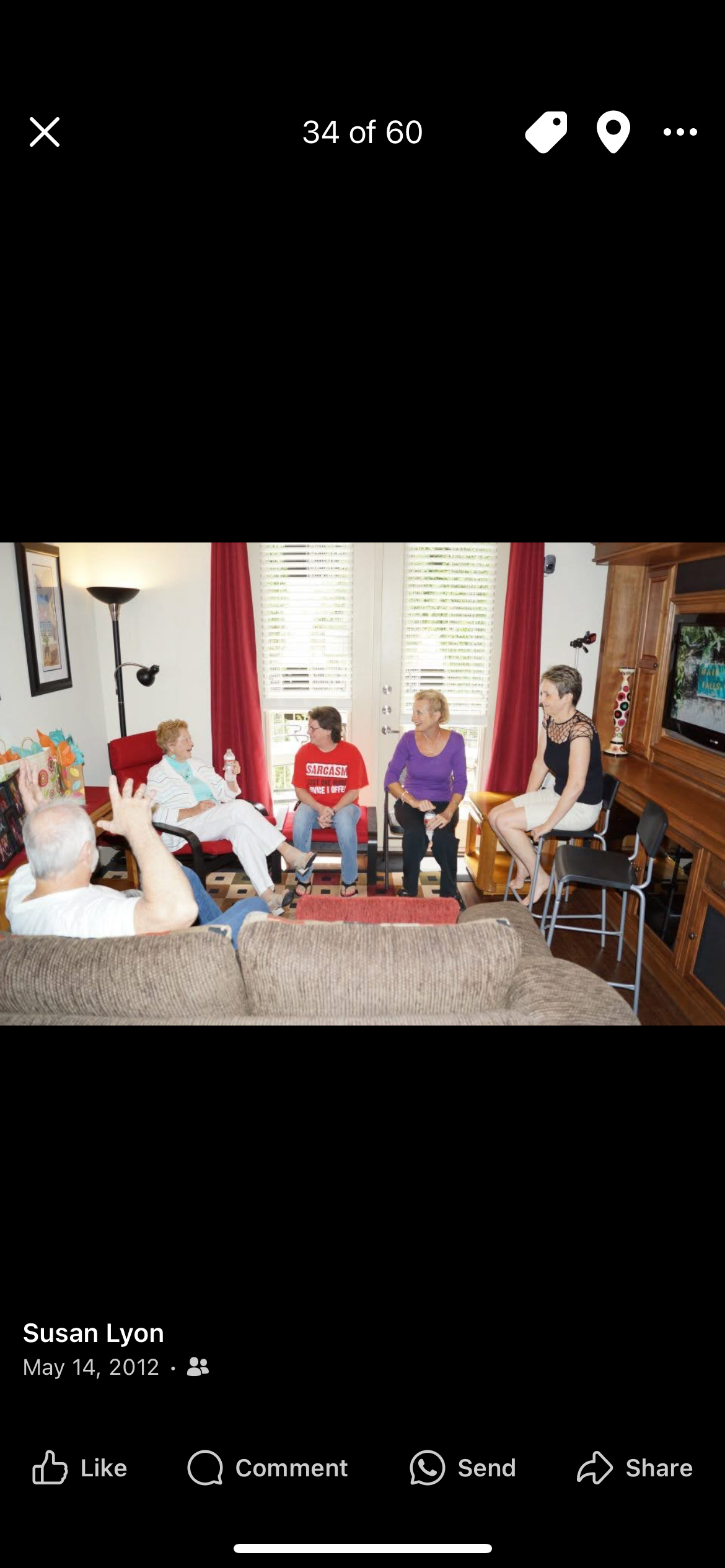 Group of people engaging in lively conversation in a warm, inviting living room setting.