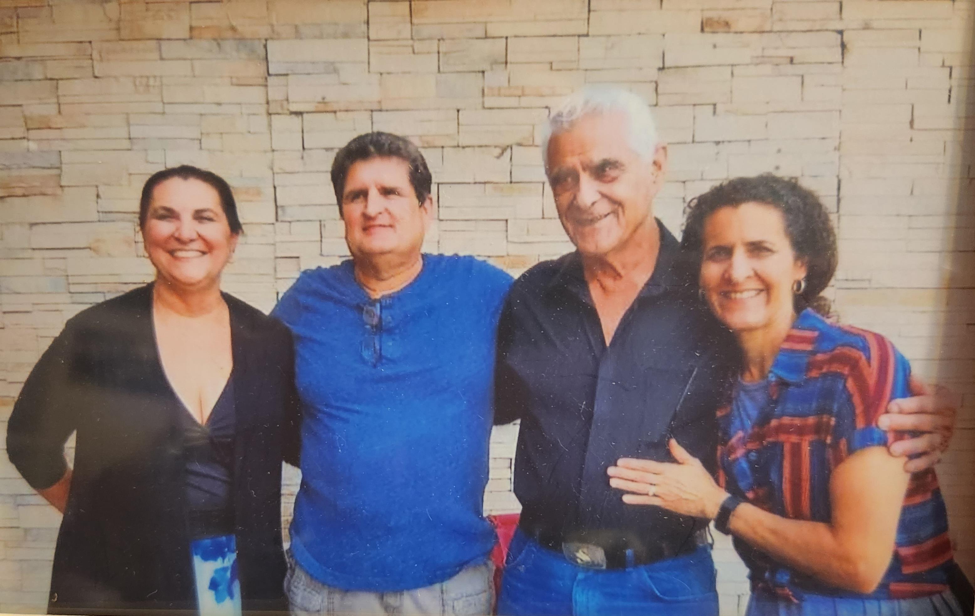 Four friends smile and enjoy each other's company in a welcoming atmosphere indoors.