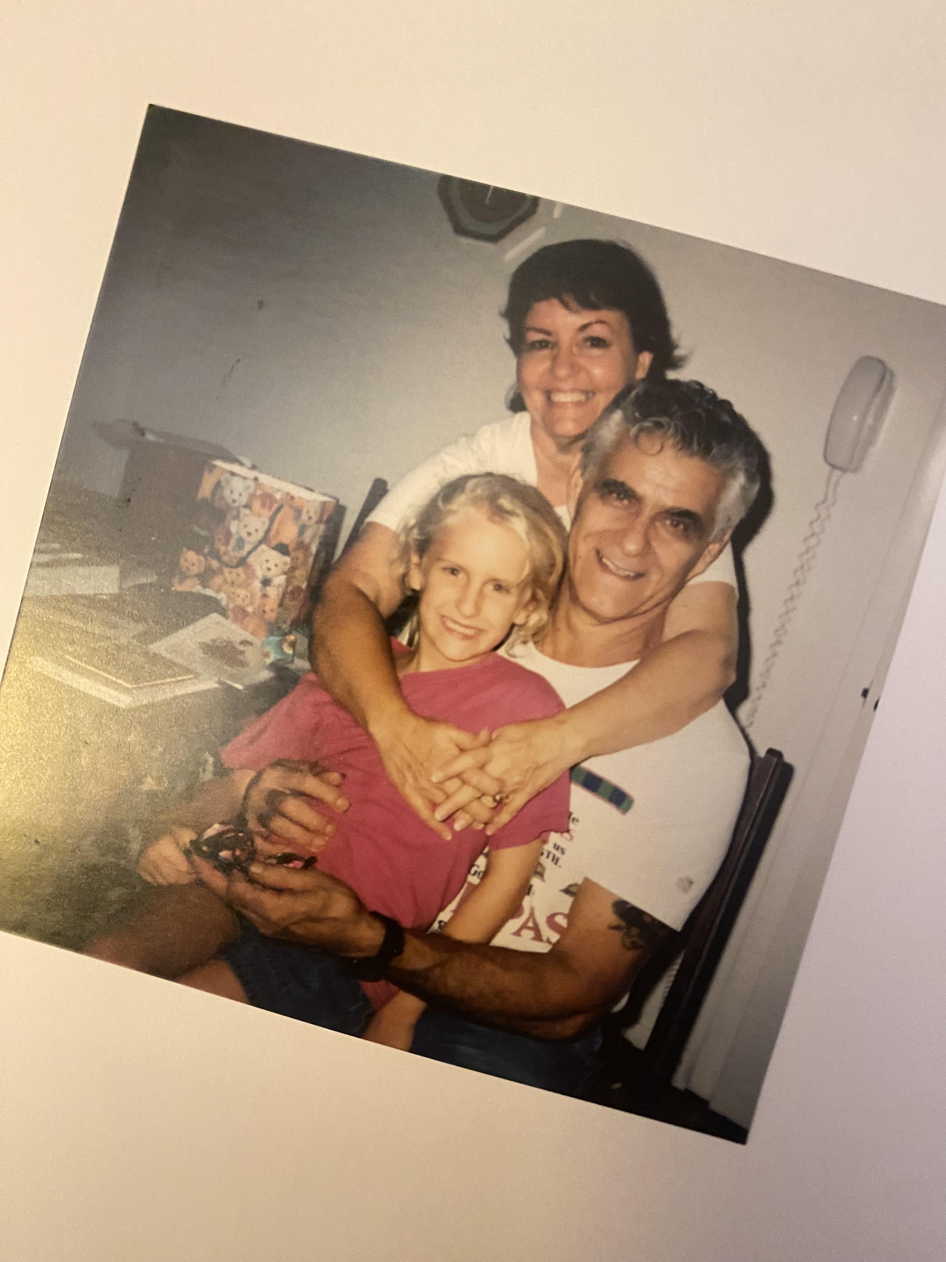 A granddaughter shares a loving moment with her grandparents while sitting together at home.