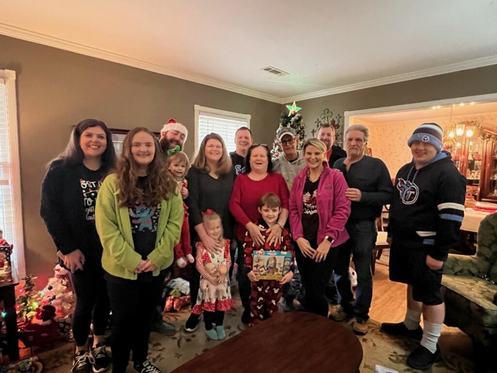 A joyful family gathers together in a decorated living room for a holiday celebration.