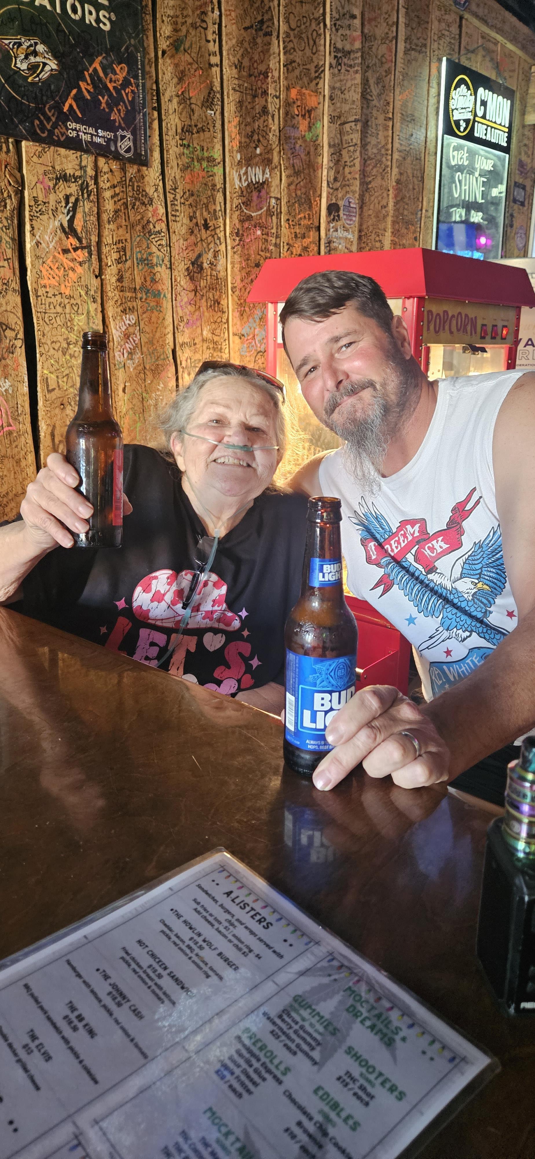 Two individuals enjoying drinks at a bar, smiling and sharing a joyful moment together.