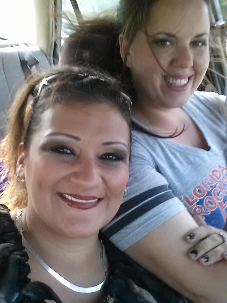 Two friends share laughs and smiles while enjoying a car ride together on a sunny day.