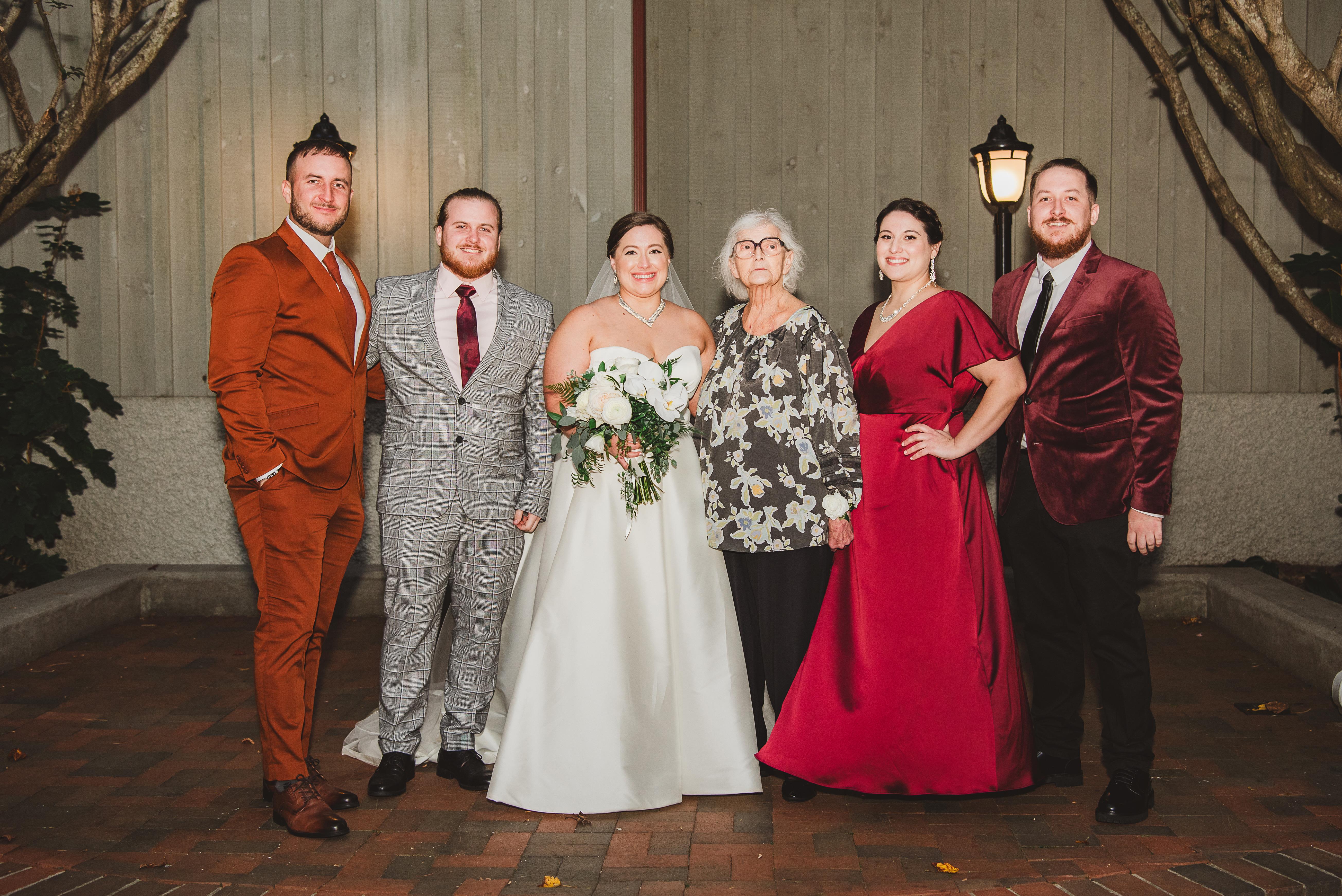 Friends and family gather for a formal wedding celebration under warm lighting.