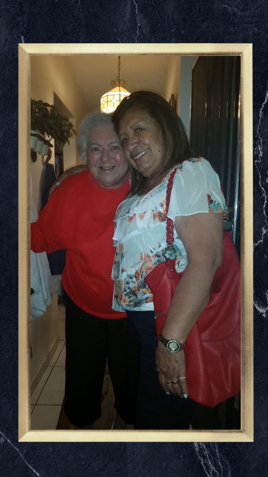 Two women enjoy a happy moment together, highlighting their friendship in a cozy space.