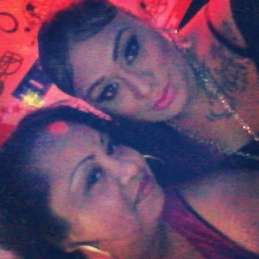 Friends smile and pose together, enjoying a lively night with vibrant lights and music.