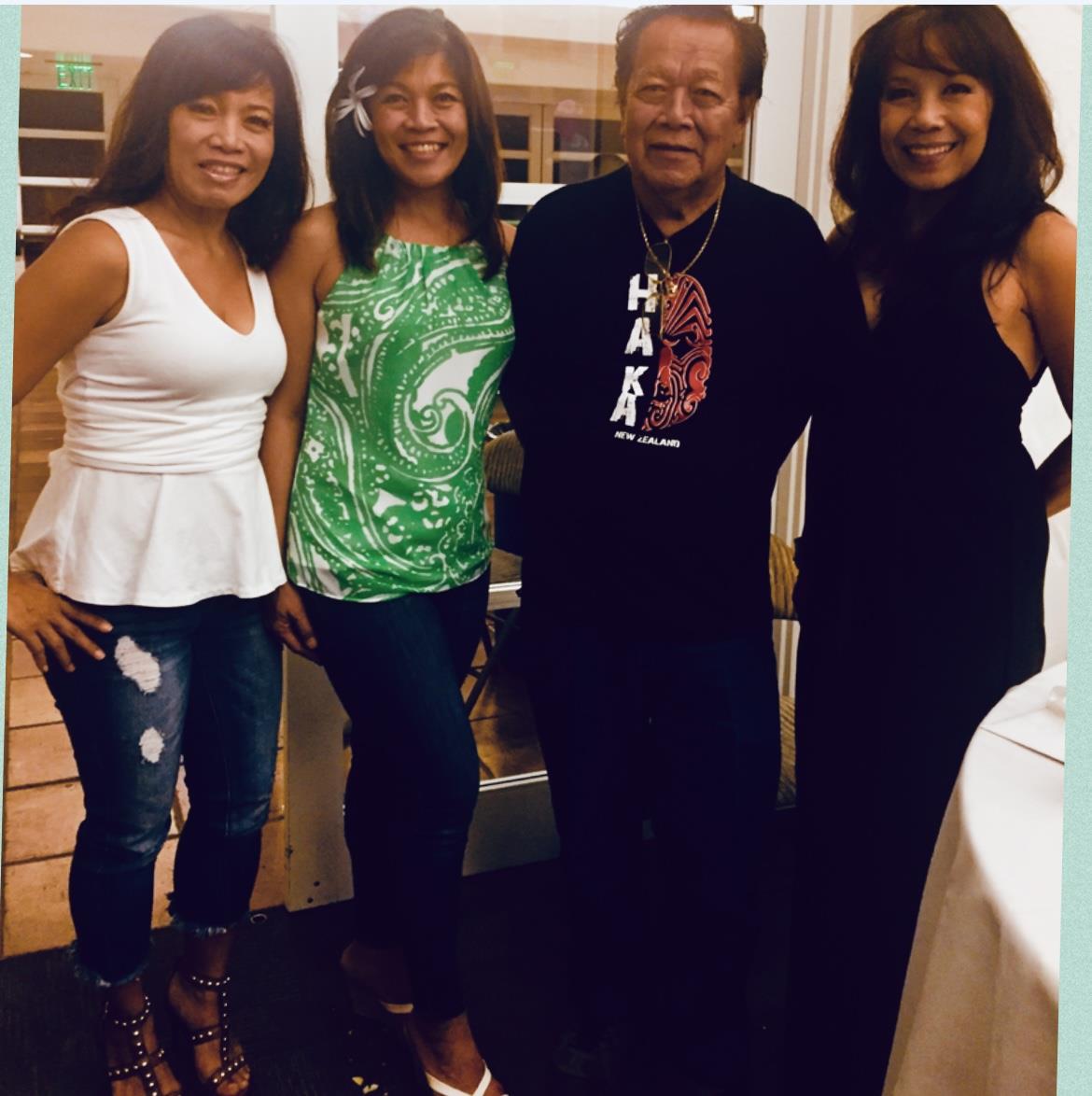 Friends pose happily together during a social event, sharing smiles and laughter in a cozy setting.