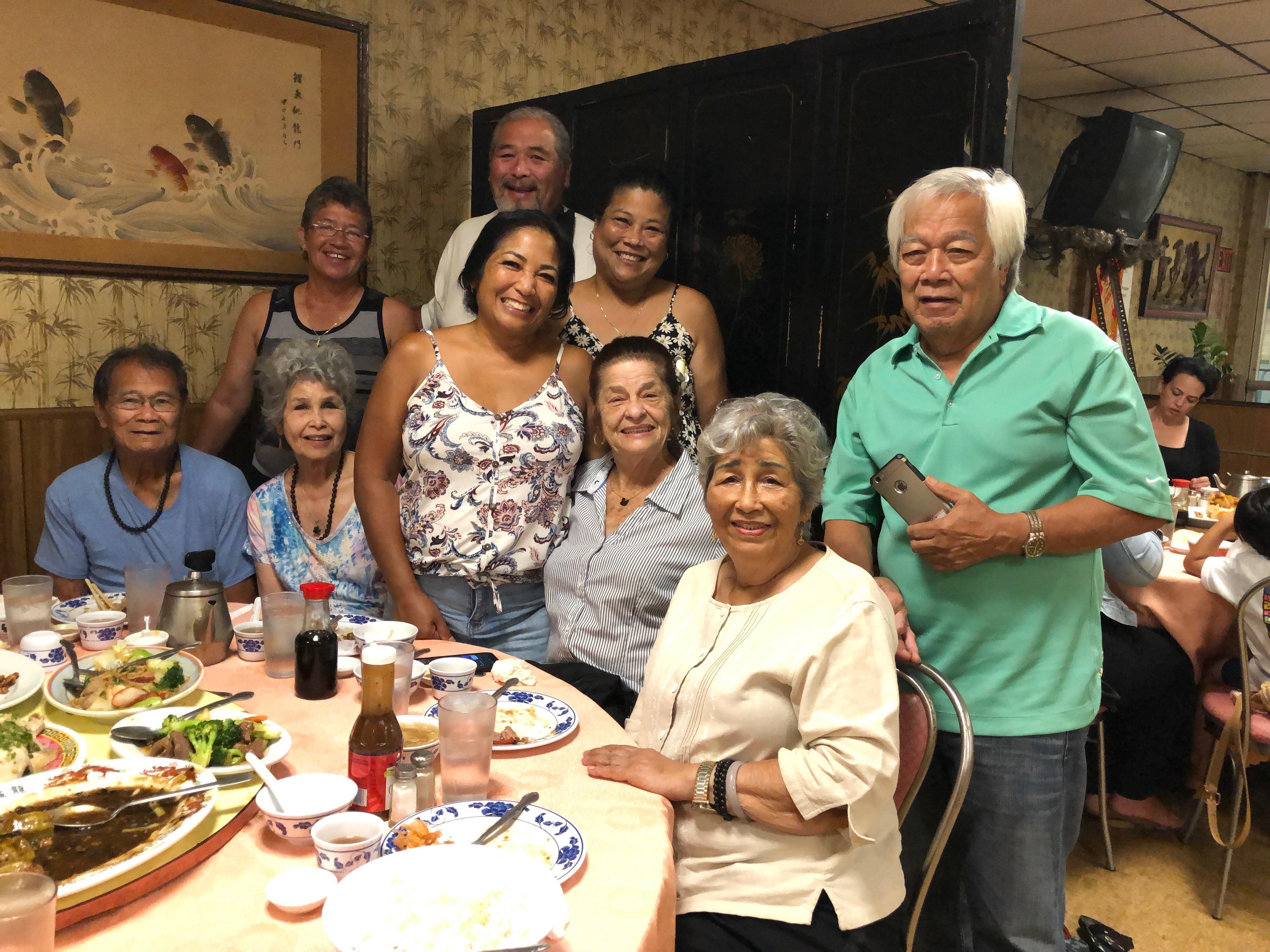 Friends gather at a table of tasty dishes, sharing laughter and stories in a cozy setting.