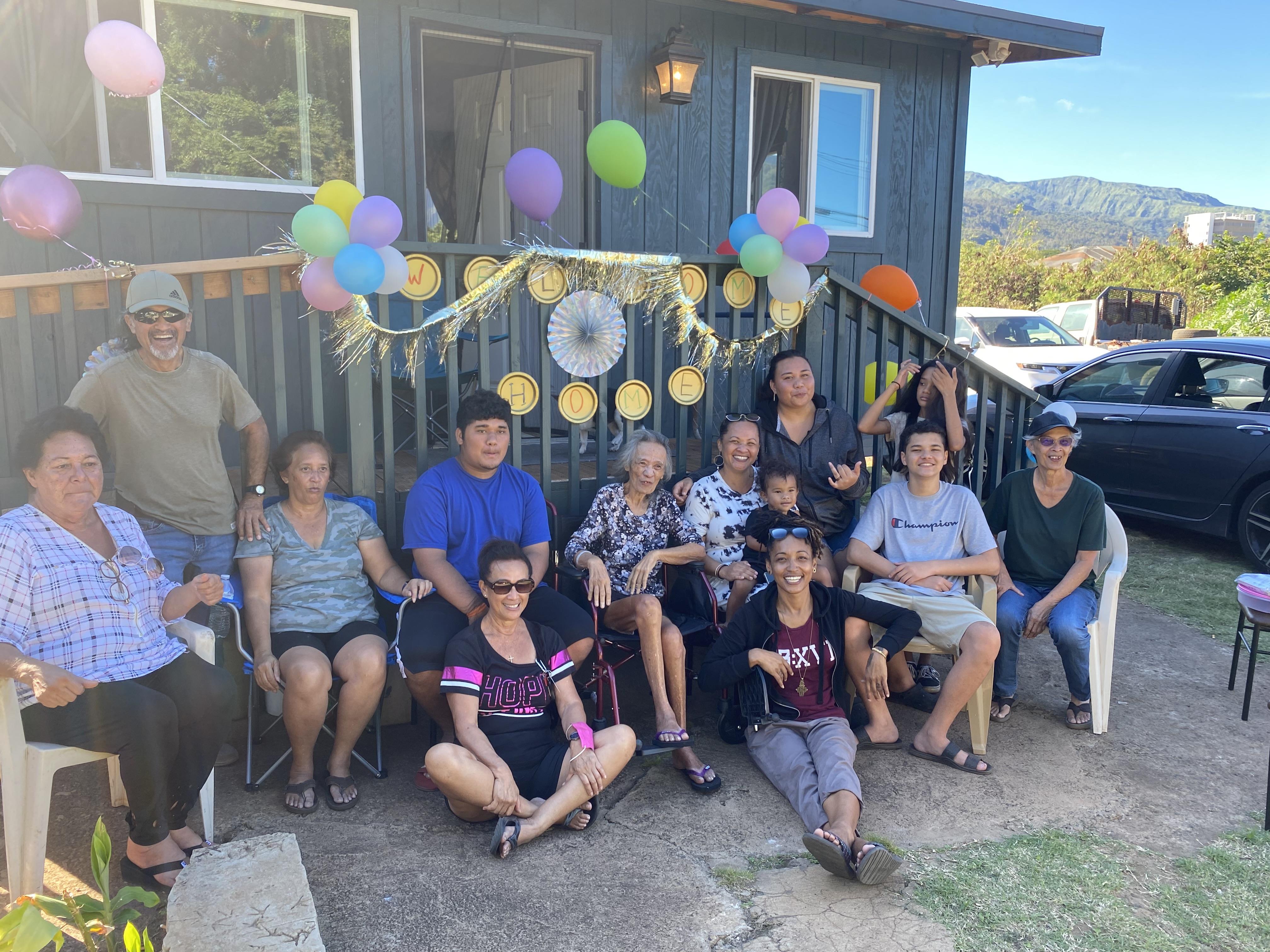 Multiple generations enjoy a joyful family gathering outside, surrounded by festive decorations.