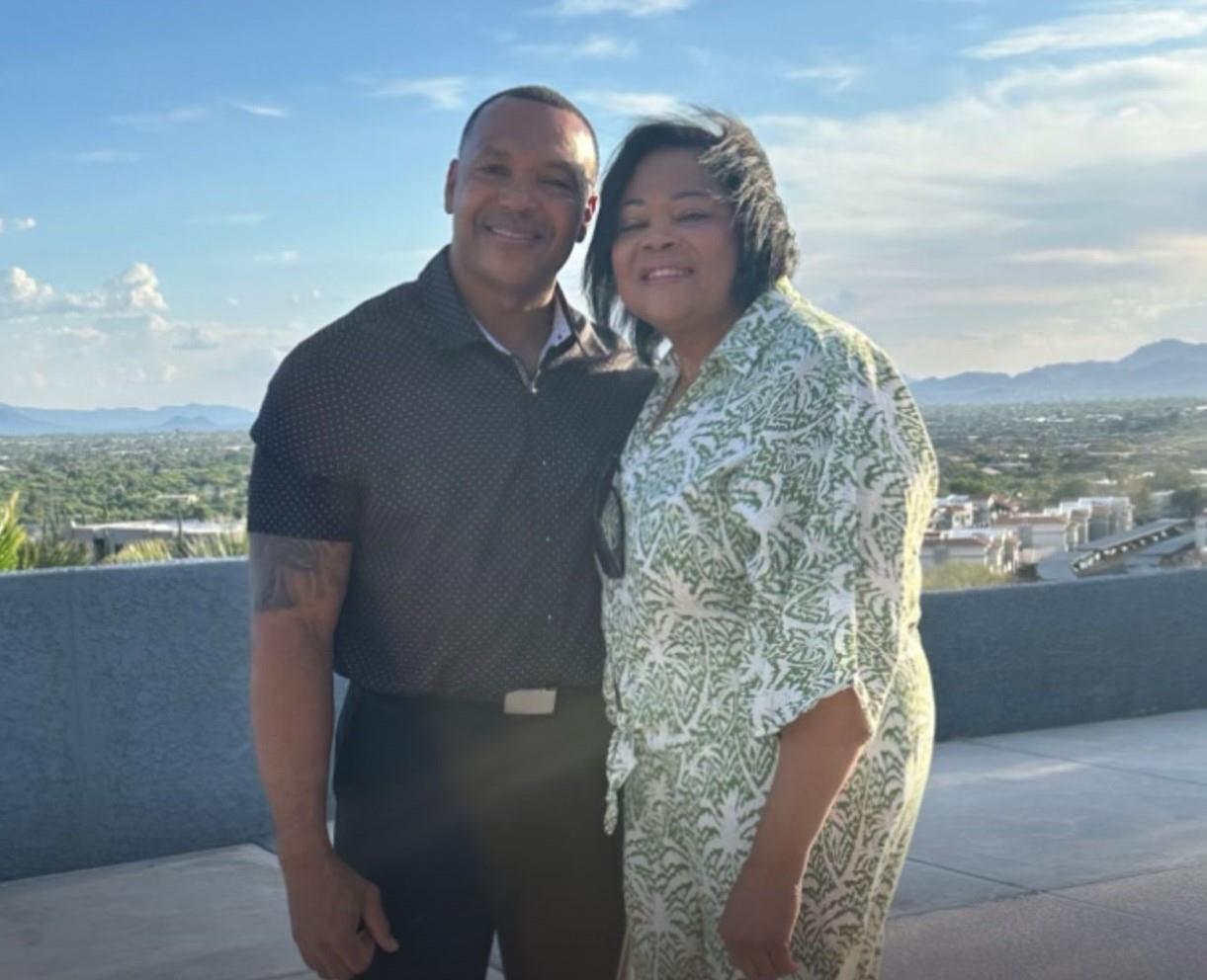Couple poses happily together against a scenic backdrop during sunset in the city.