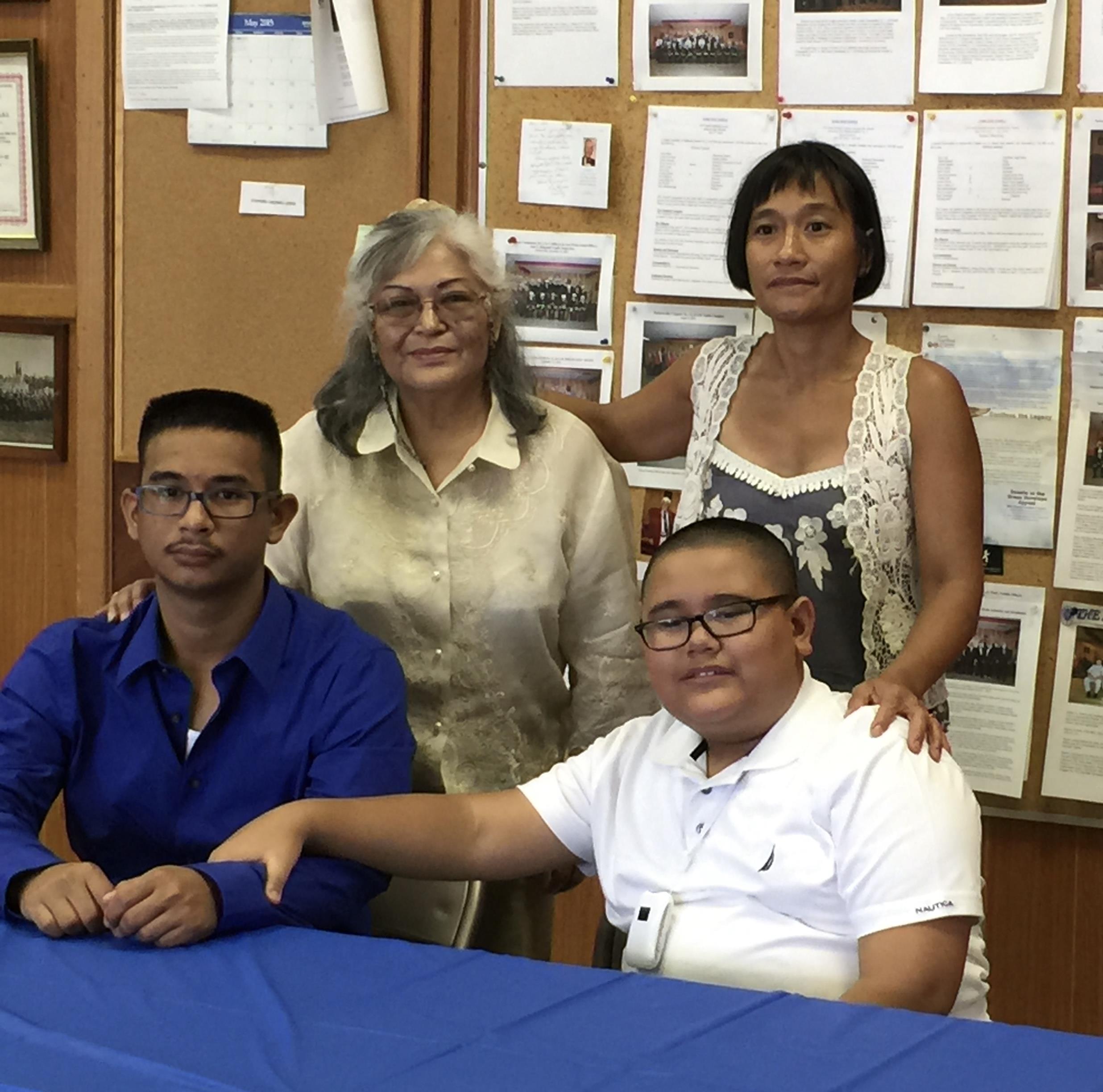 Family members pose happily at a community center event celebrating achievements and connections.