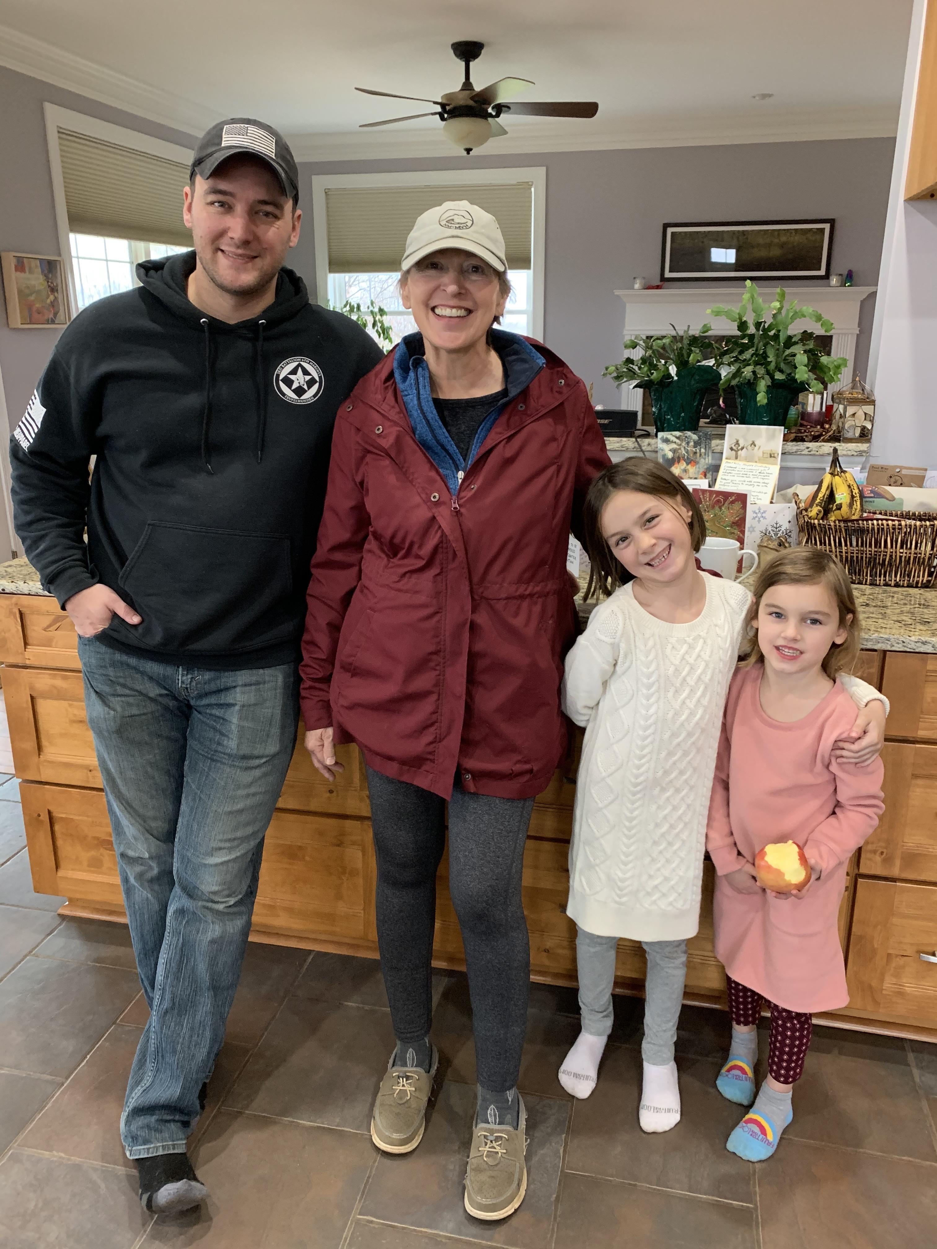 Family members gather in the kitchen, smiling and enjoying each other's company on a winter day.