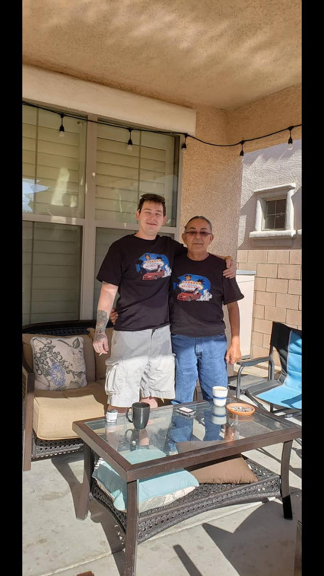 Men are smiling and bonding on a cozy patio while sharing drinks and snacks.