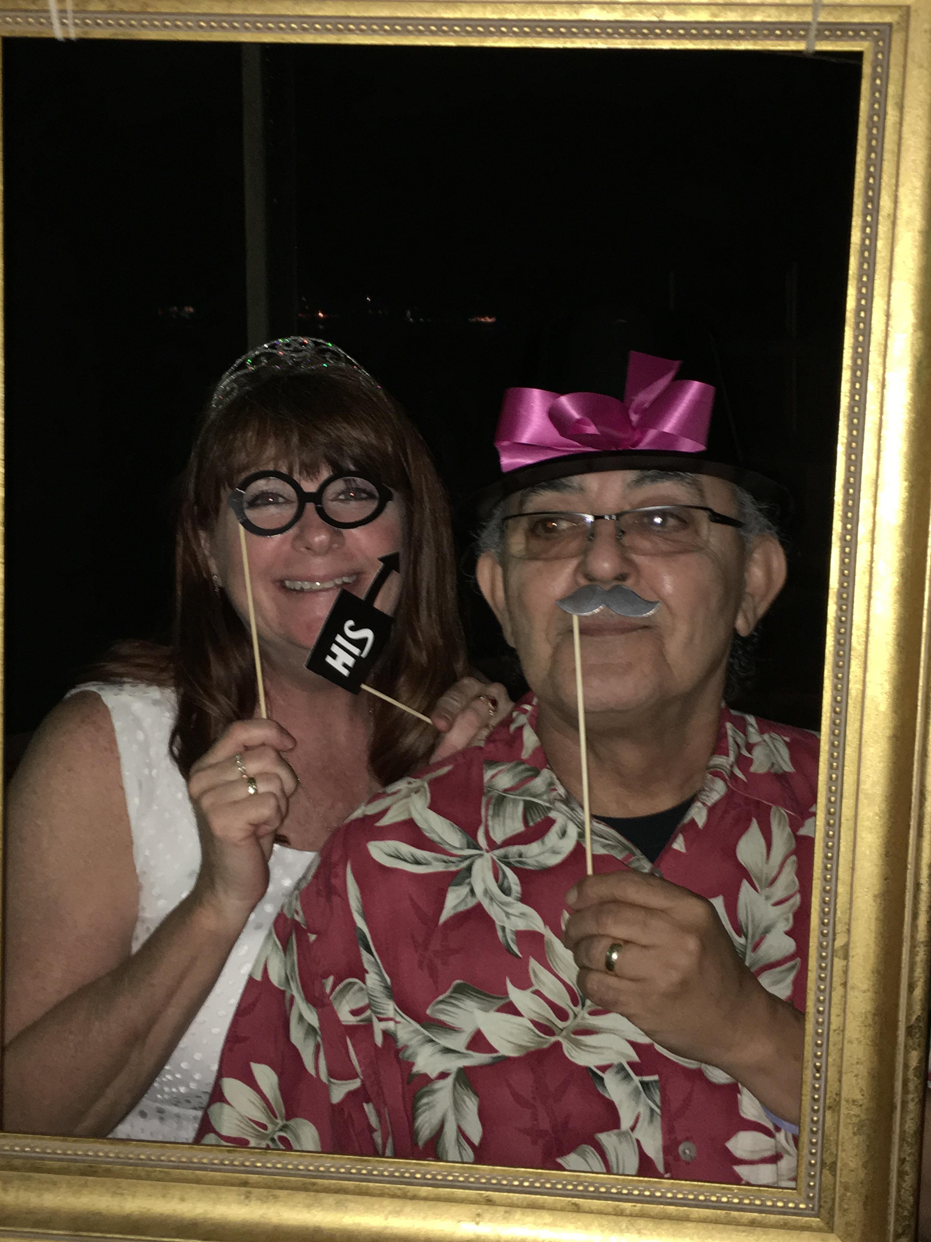 Two friends pose playfully with props in a festive indoor environment, showcasing joy and humor.