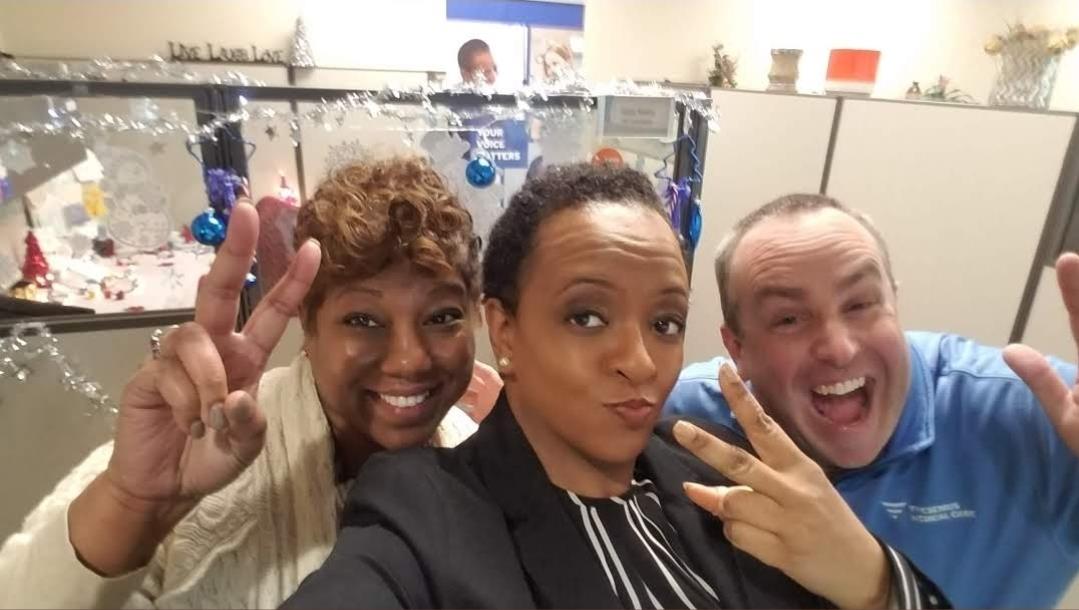 Colleagues share a cheerful moment at work while celebrating the holiday season together.