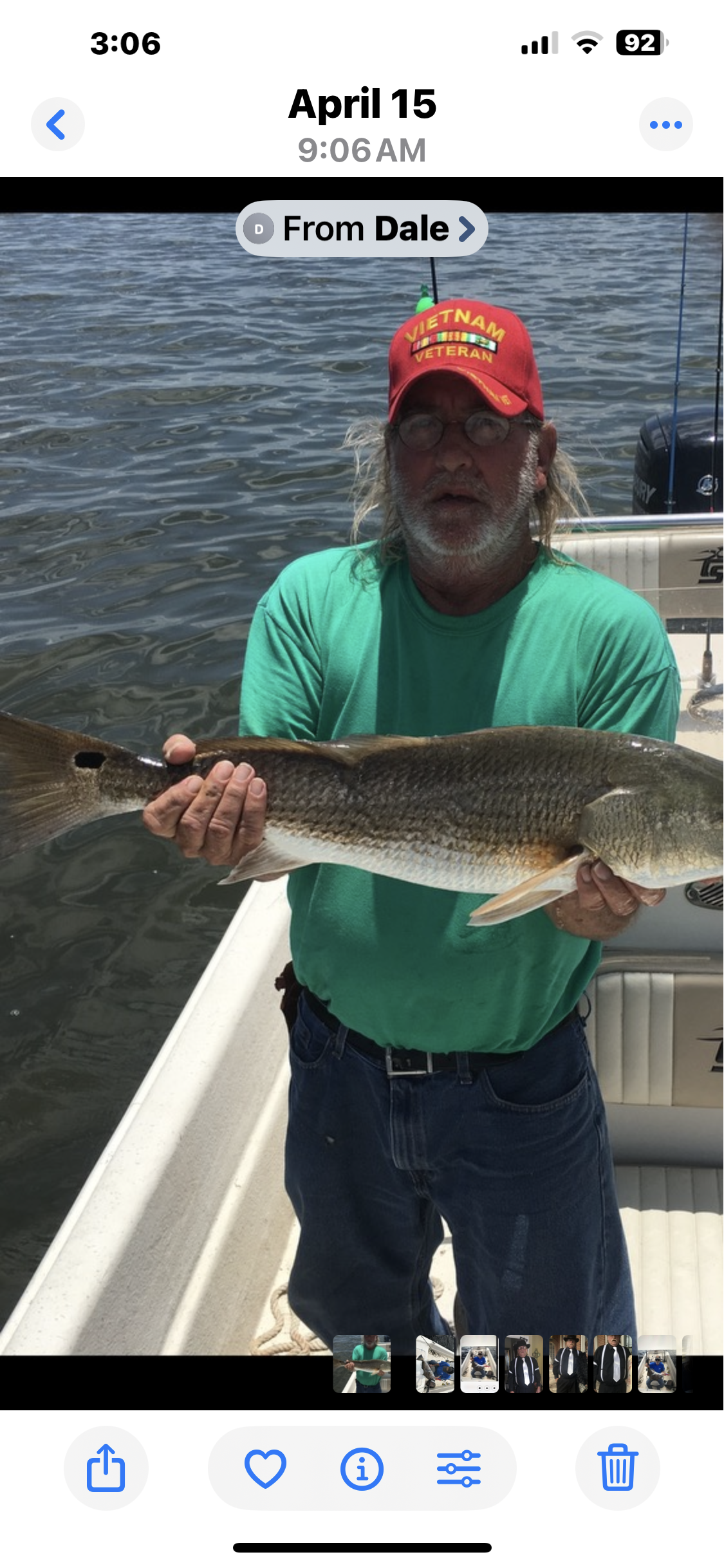 A man displays his catch, a sizeable fish, on a boat during a fishing expedition.