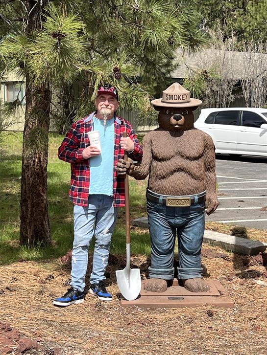 A man standing next to a statue of a bear