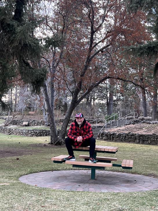 A man sitting on a picnic table