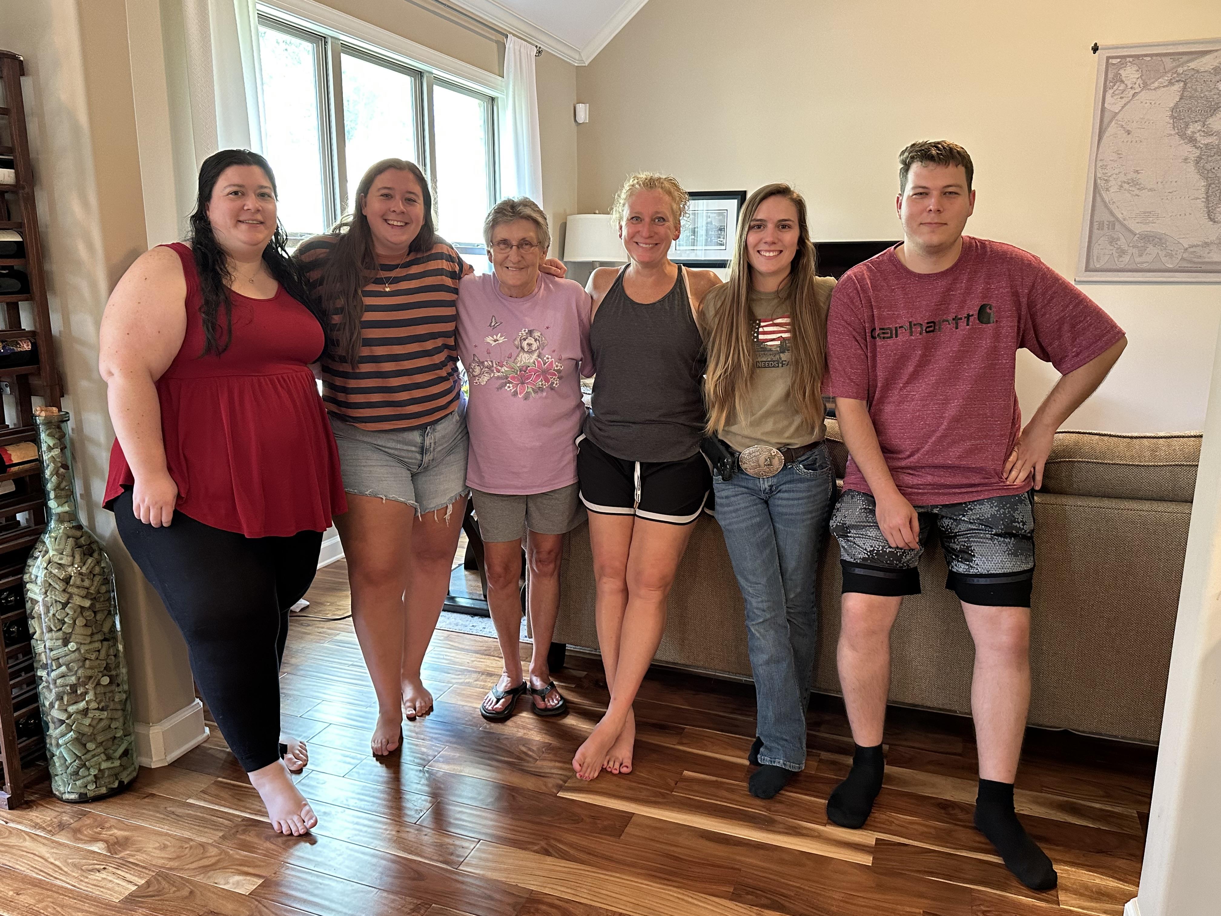 Family members enjoying time together in a well-lit living room with warm wooden floors.