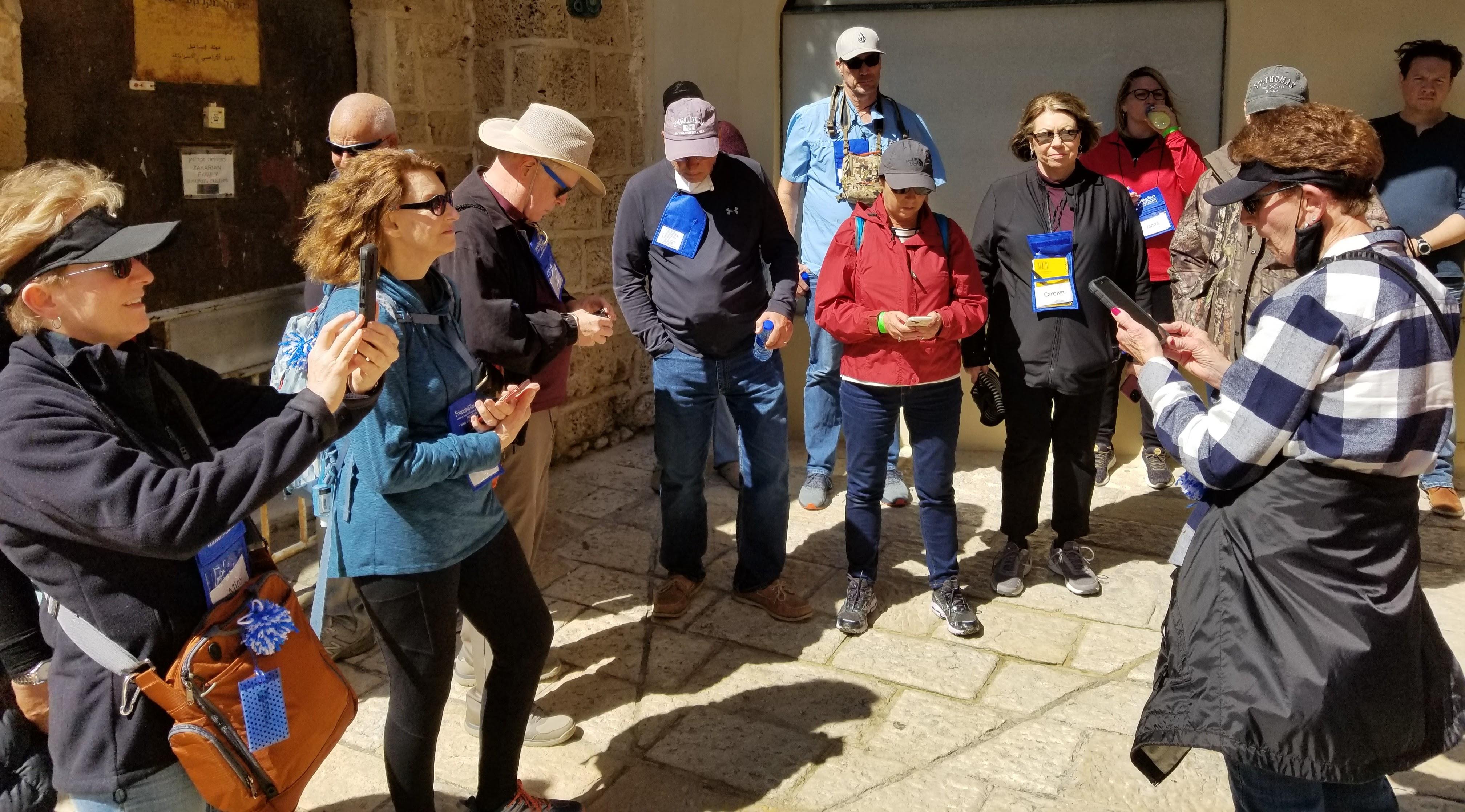 Tourists explore a charming courtyard, interacting and enjoying their time together under the sun.