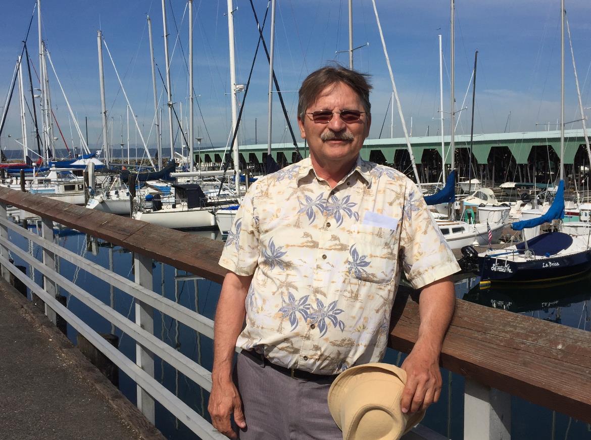 Individual enjoys a sunny day at the marina, surrounded by boats and clear skies.