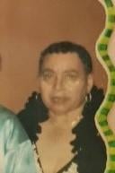 A stylish senior woman stands with friends at a lively gathering in a bright venue.