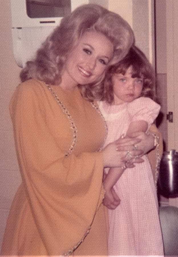 Two smiling individuals stand in a cozy kitchen, showing their genuine affection.