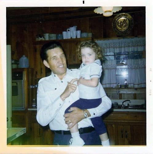 A father gently holds his daughter in a warm kitchen filled with nostalgia and love.