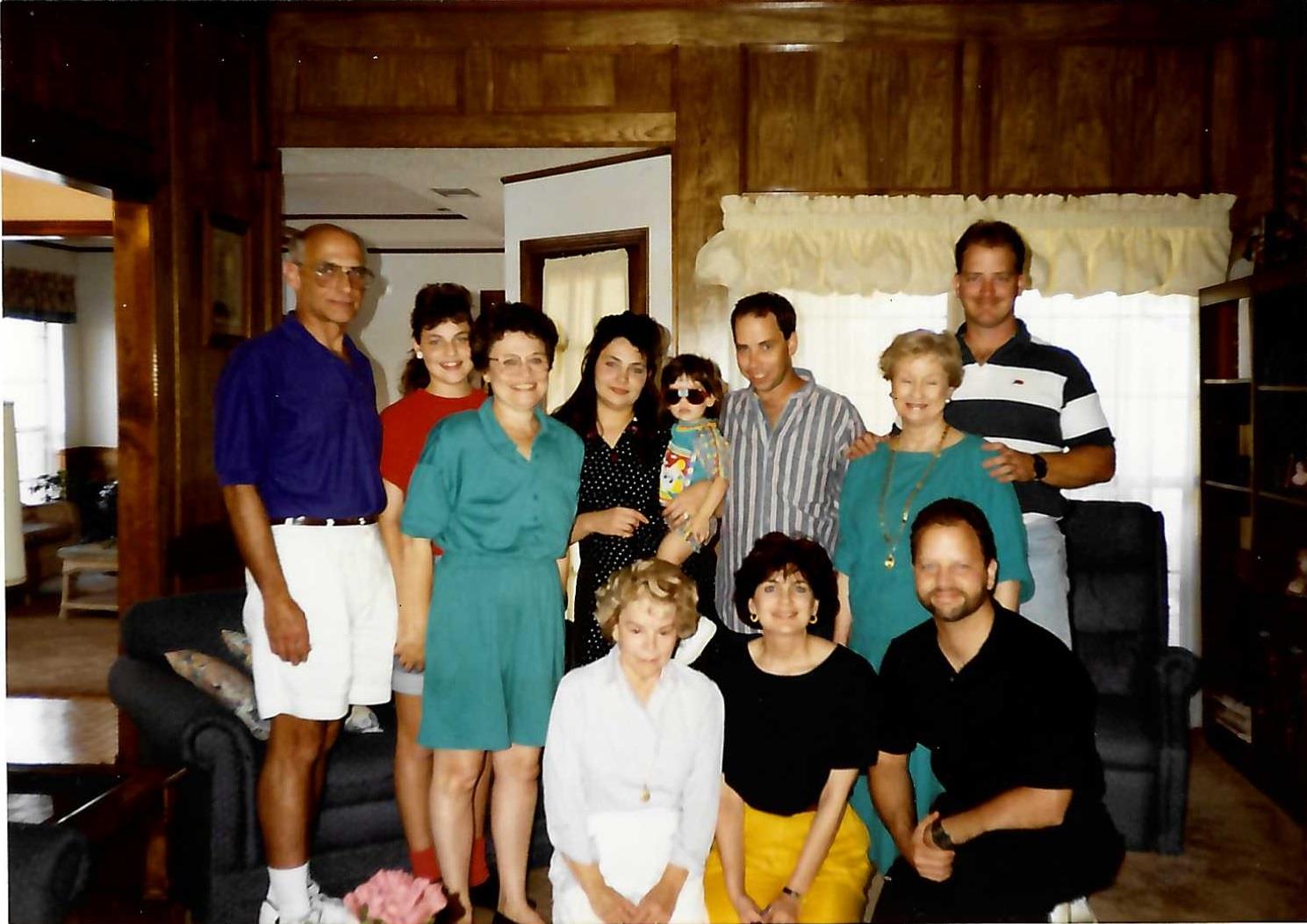 Family members smile together in the living room, enjoying each other's company.