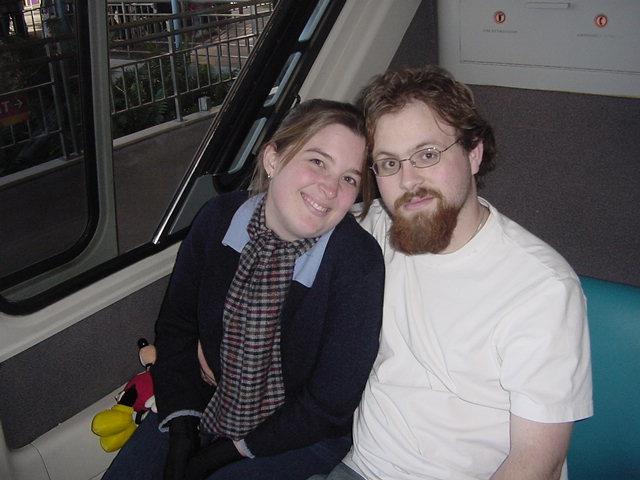 A couple relaxes together on a gondola, smiling and enjoying a pleasant ride through the city.