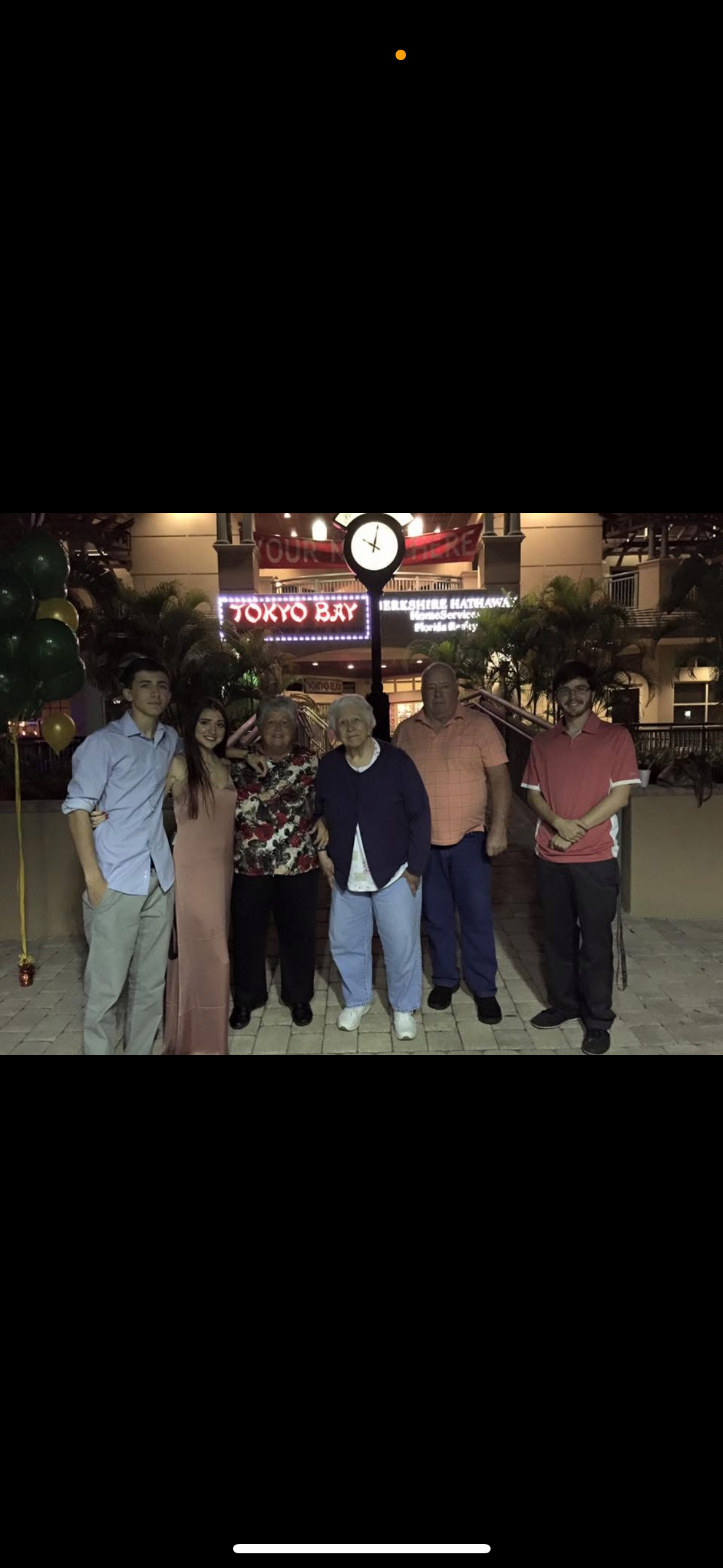 Friends gather outside Tokyo Bay restaurant, enjoying a joyful moment during an evening celebration.