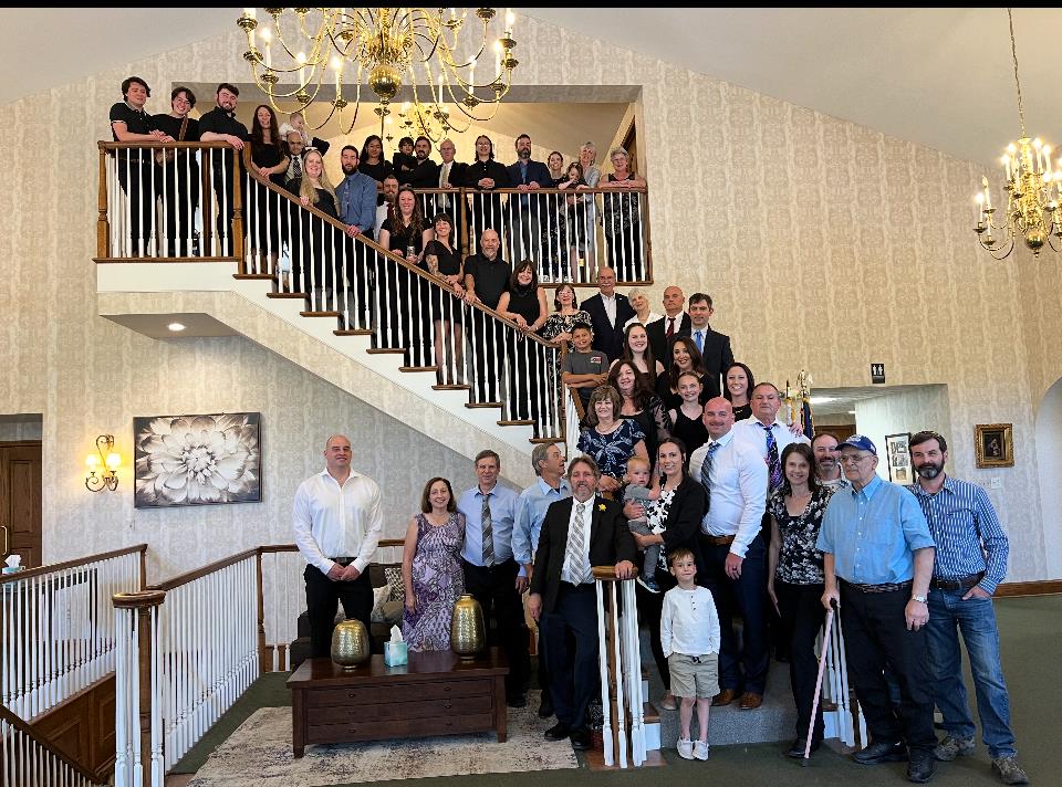 A joyful family reunion is taking place at a stylish venue featuring a grand staircase.