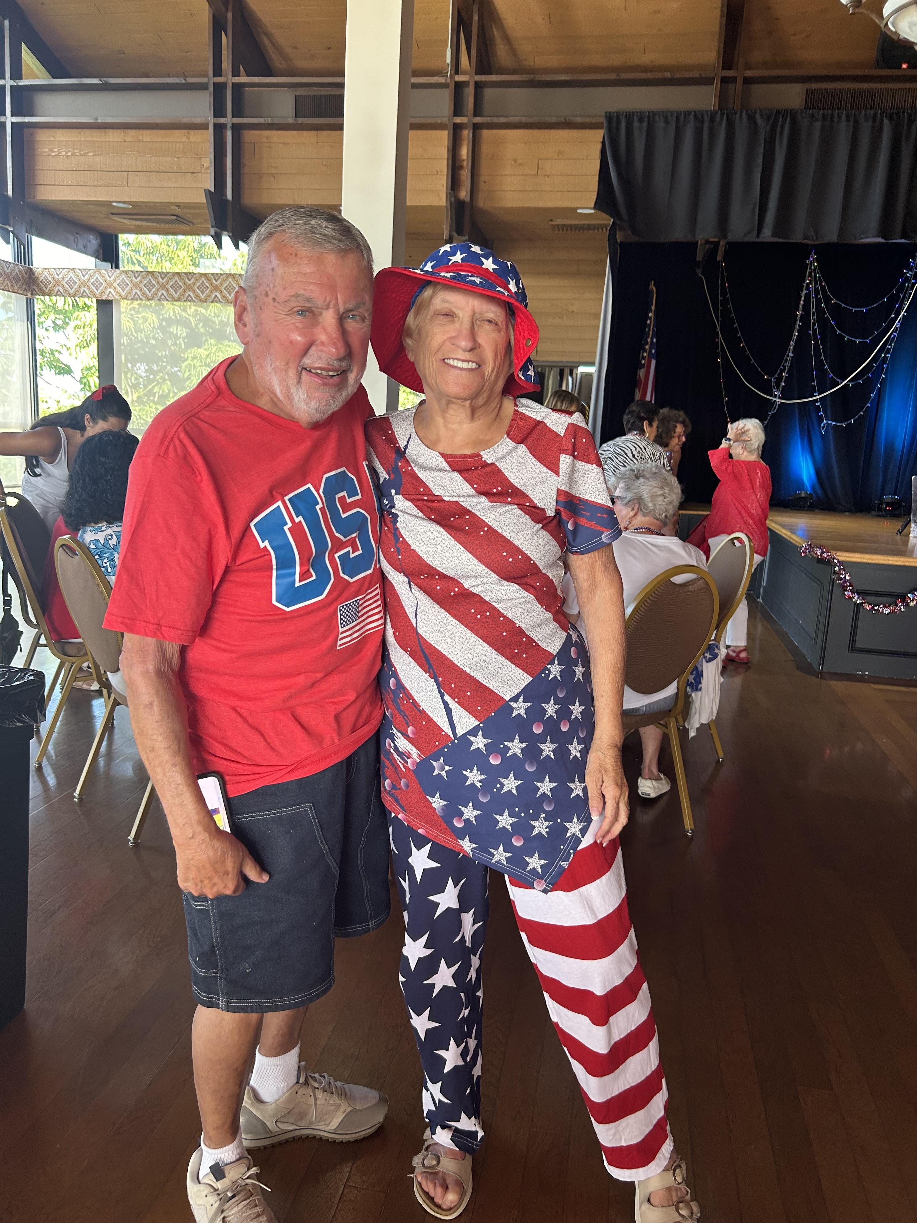 Joyful couple dressed in red, white, and blue enjoys a community gathering celebrating patriotism.