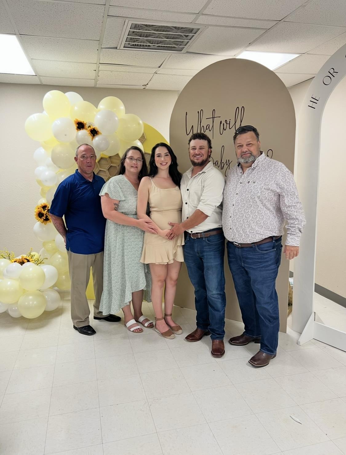 Family members gather to celebrate a baby shower with festive decorations and joy.