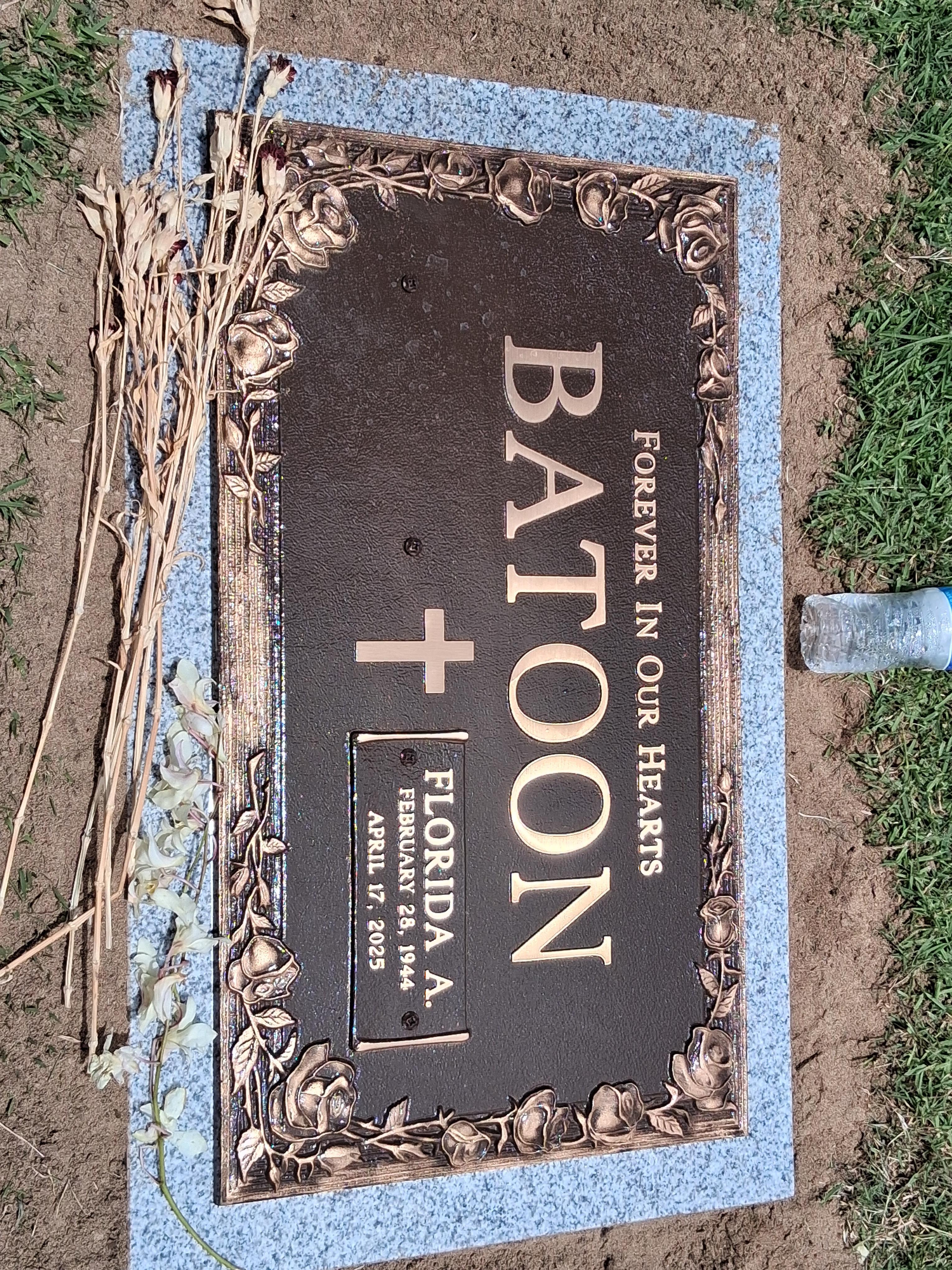 A gravestone marked with the name Batoon, honoring Florida A., in a peaceful cemetery.