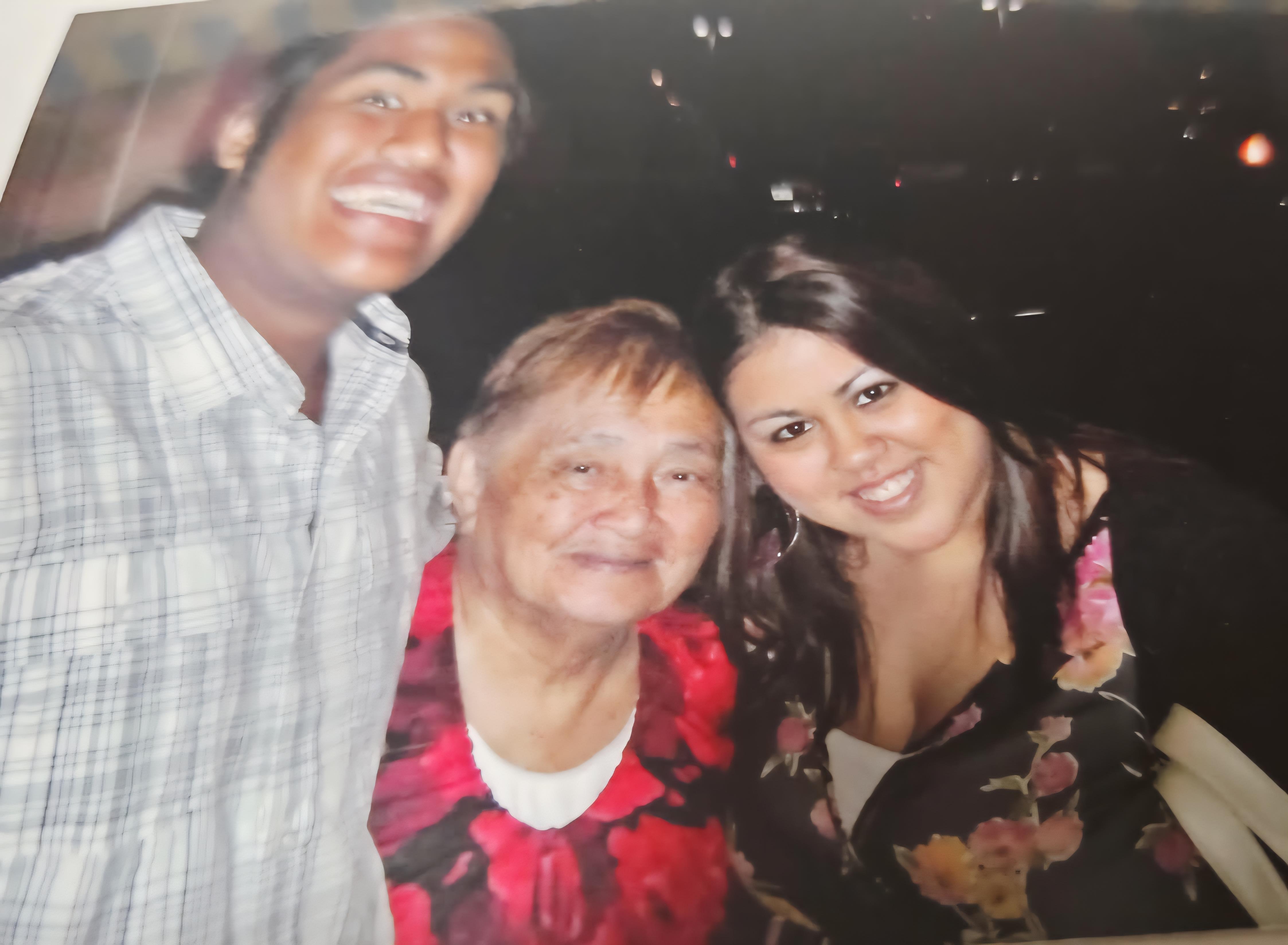 A cheerful grandmother poses with her grandchildren, smiling happily during a family gathering.