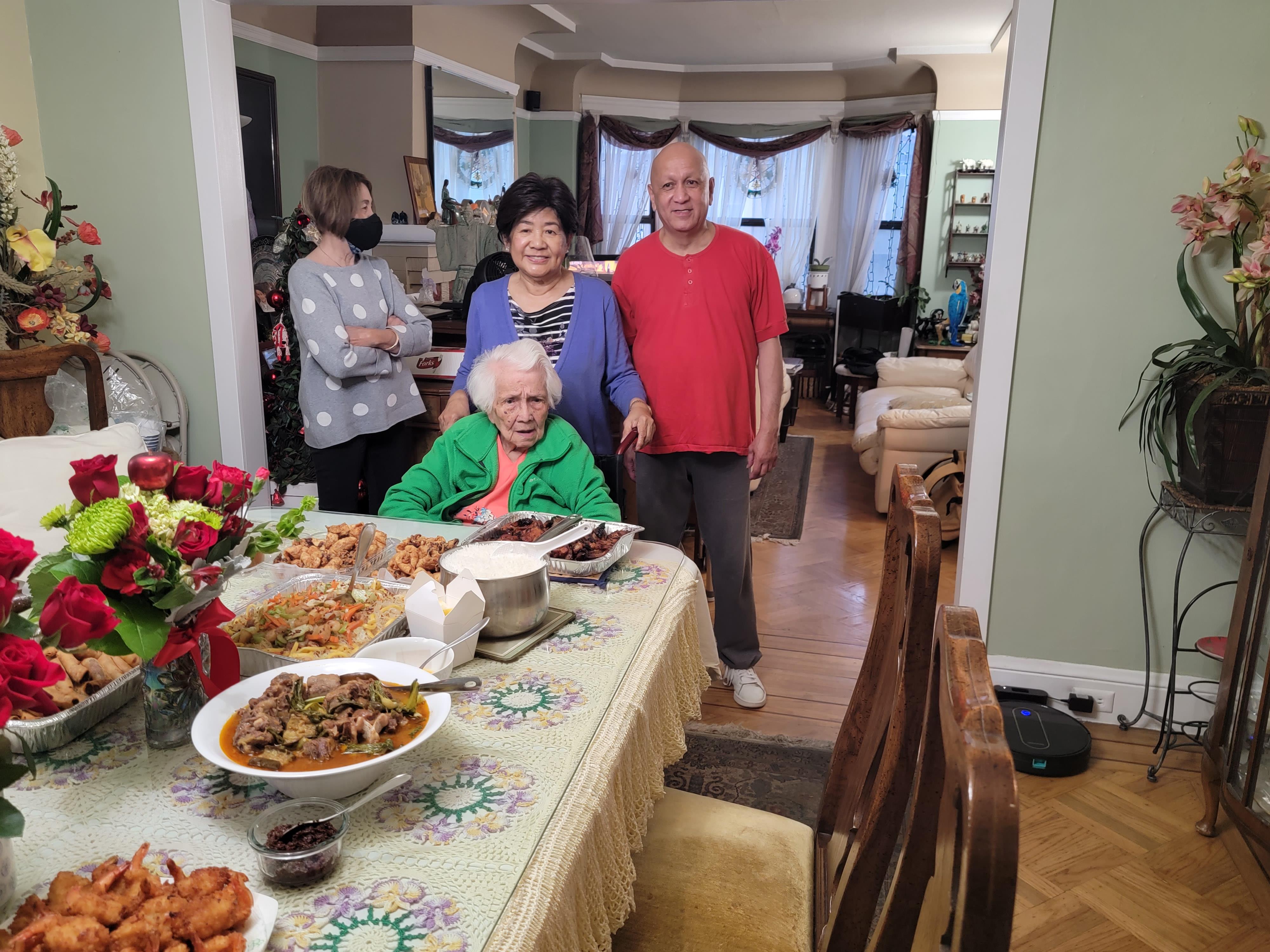Family members celebrate together in a warm living room, enjoying a delicious meal.