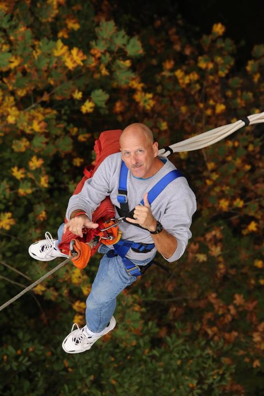 A man in a harness and a backpack