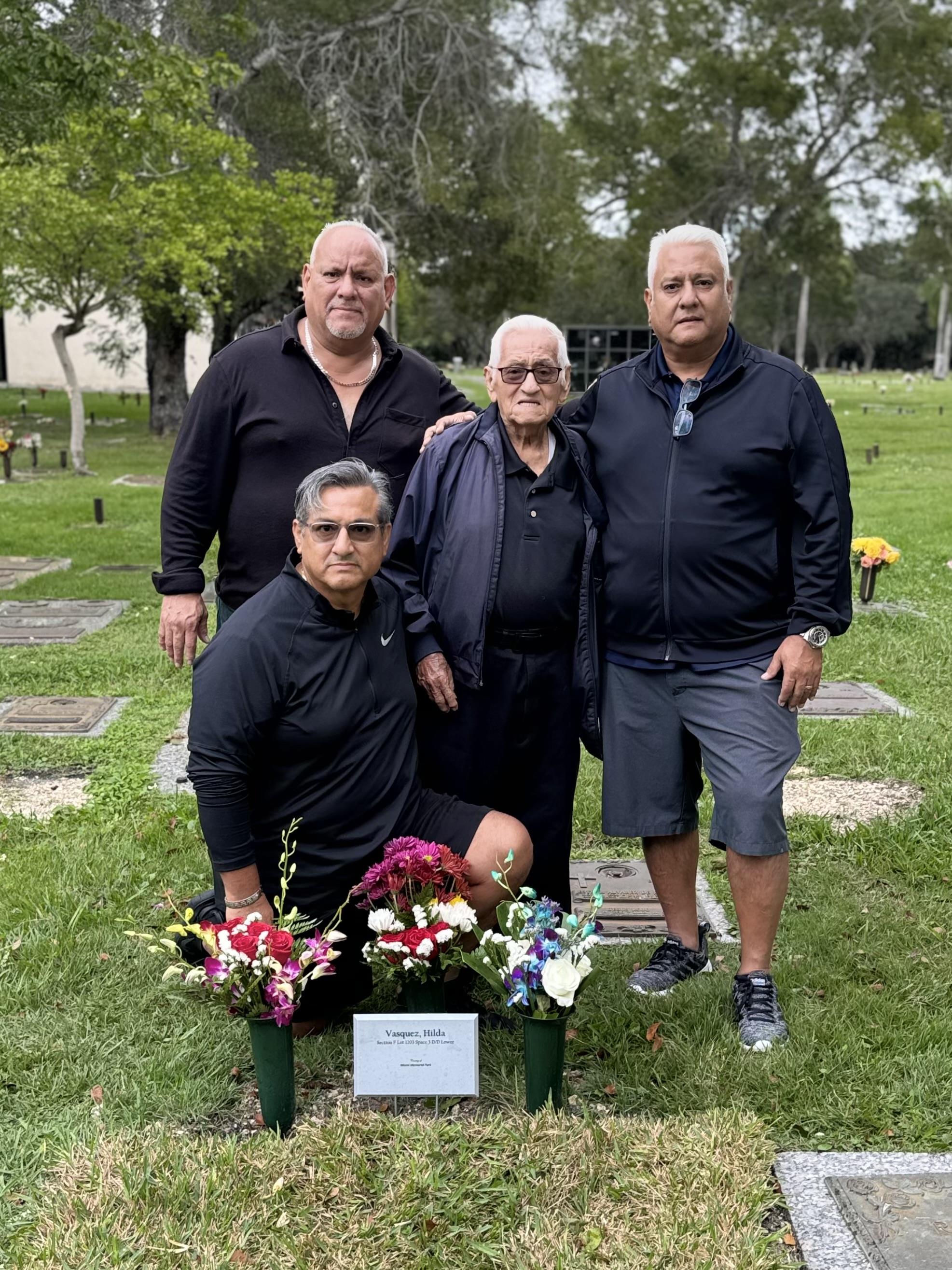 Family visits a cemetery to pay respects and celebrate the memory of a deceased relative.