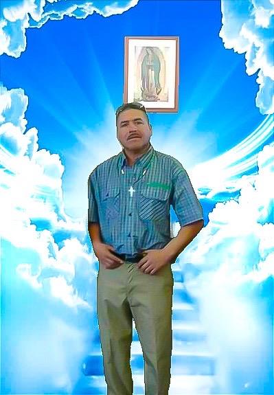A man poses in a blue and white cloud backdrop, highlighting faith and spirituality.