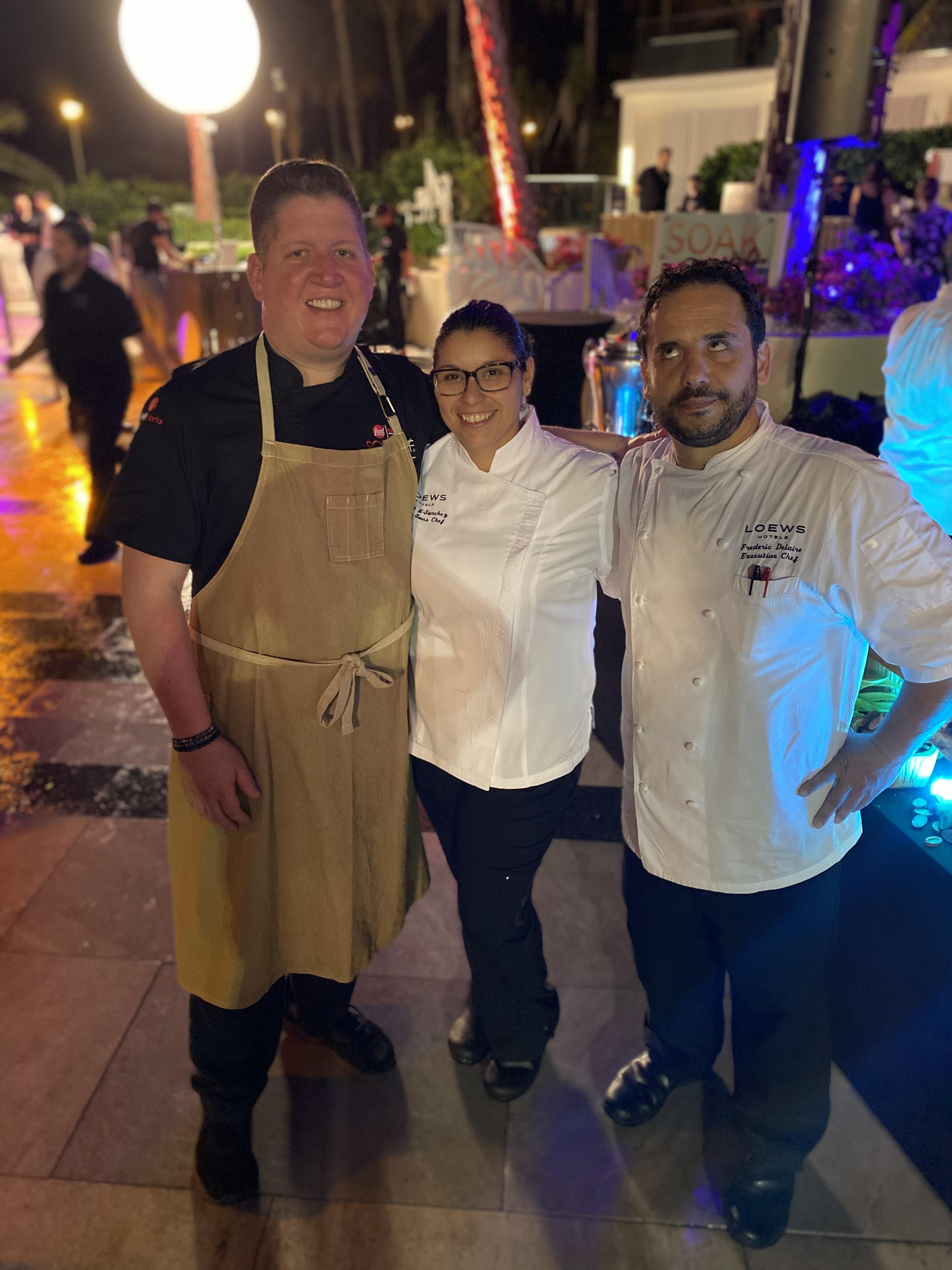 Three chefs showcase their culinary skills at a vibrant nighttime event with colorful lights.