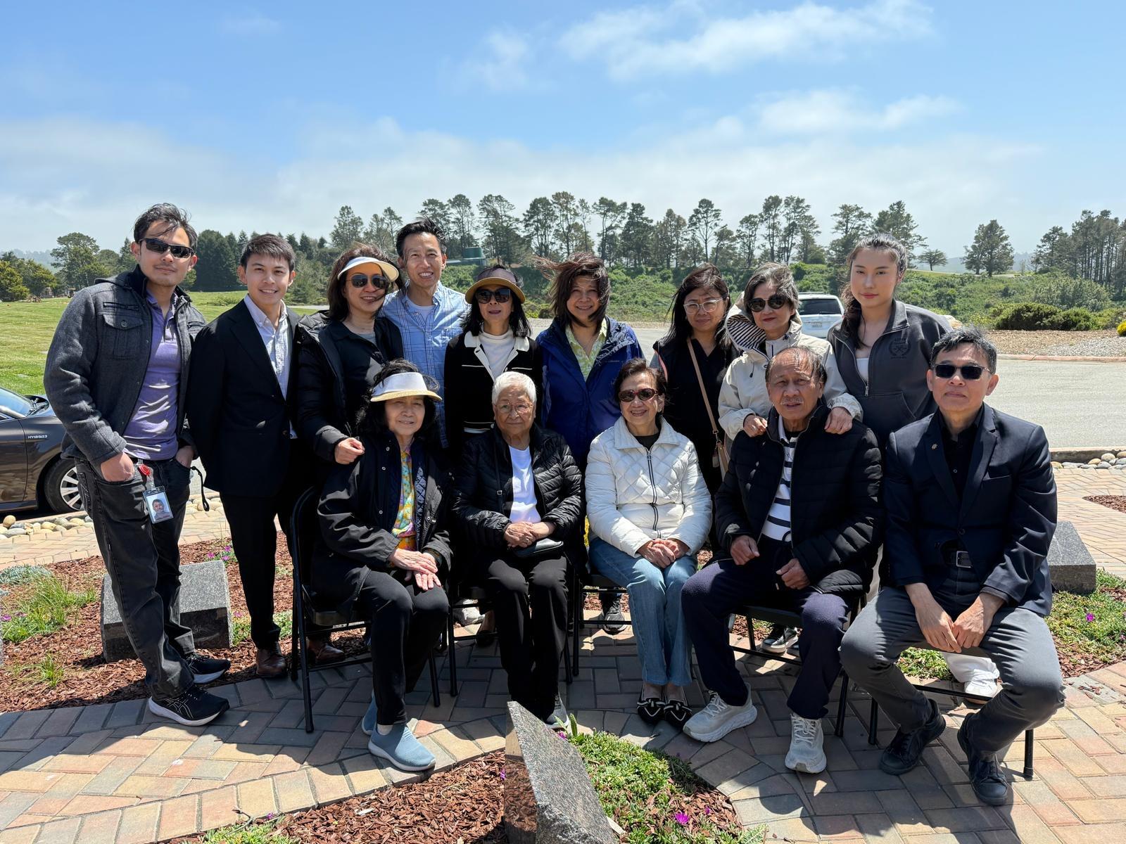 Diverse group of family members enjoying a sunny day outdoors, celebrating together at the park.