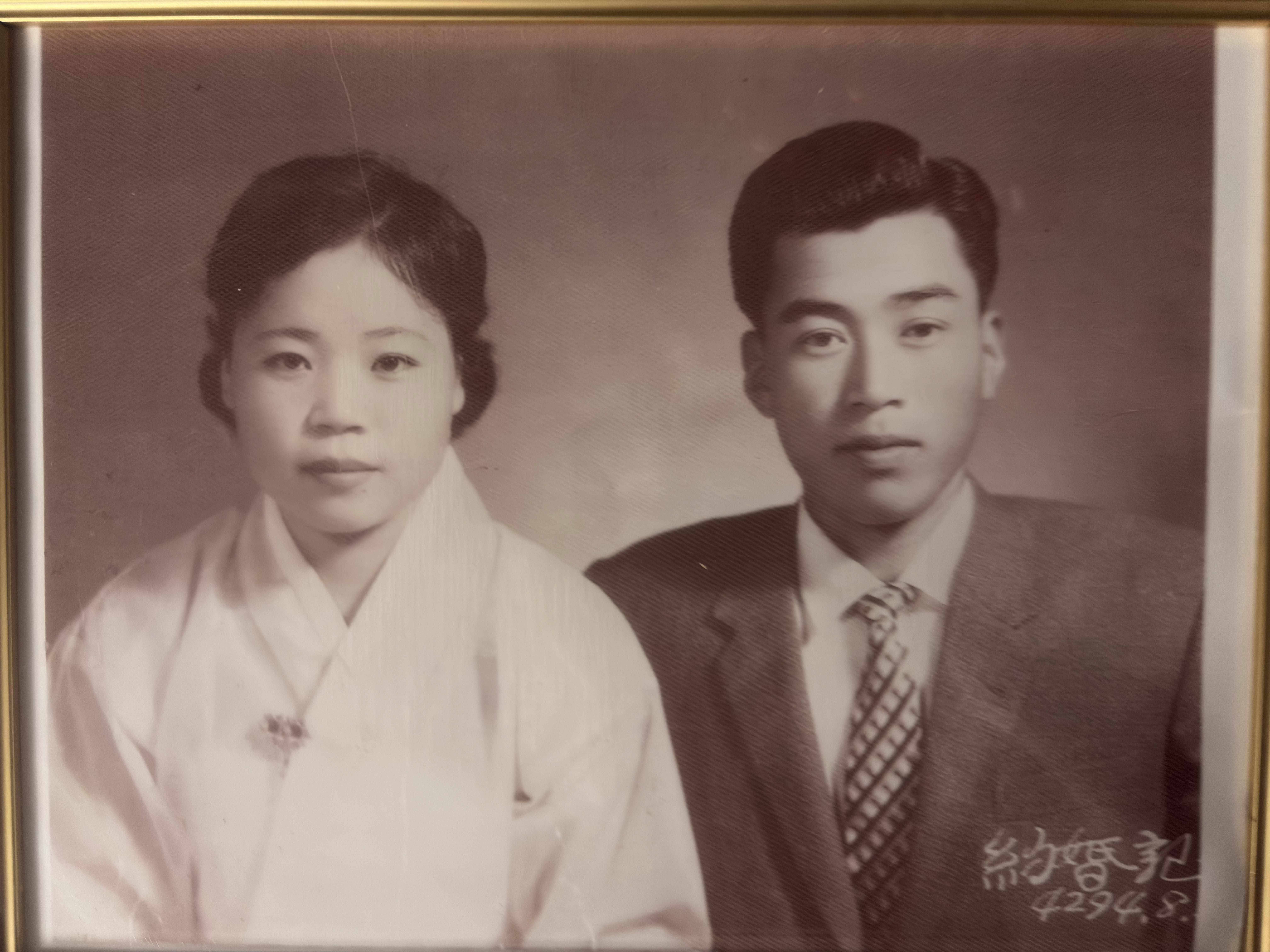 A couple in formal attire showcases cultural styles from the past.