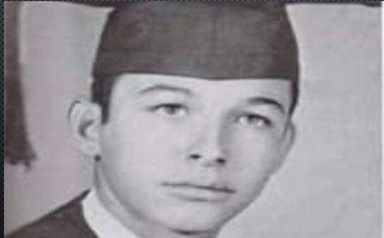A close-up of a young man wearing a graduation cap