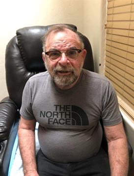 An elderly man relaxes in a recliner, enjoying a soothing foot massage at a wellness center.